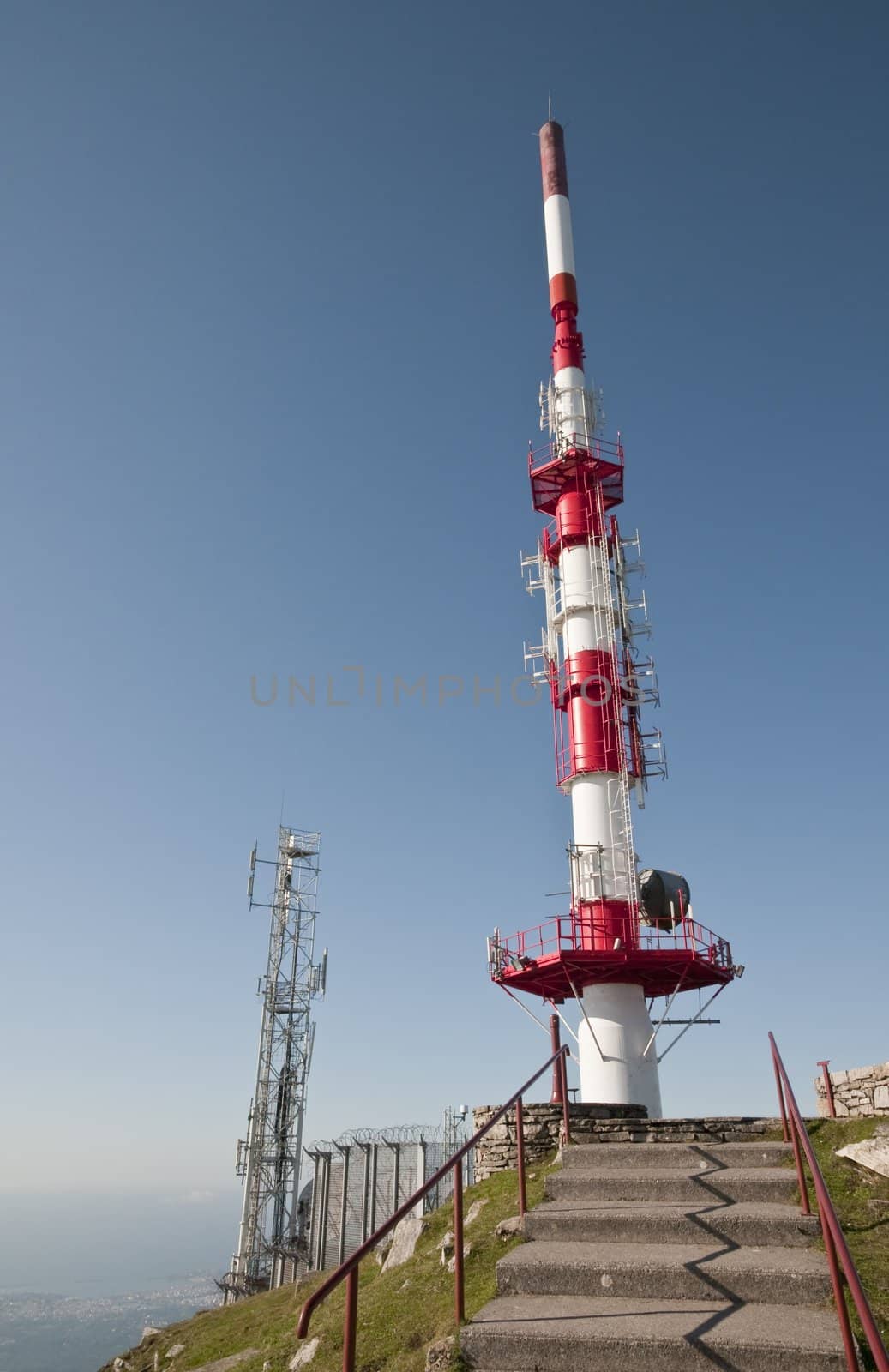 Big red and white antenna on a blue sky