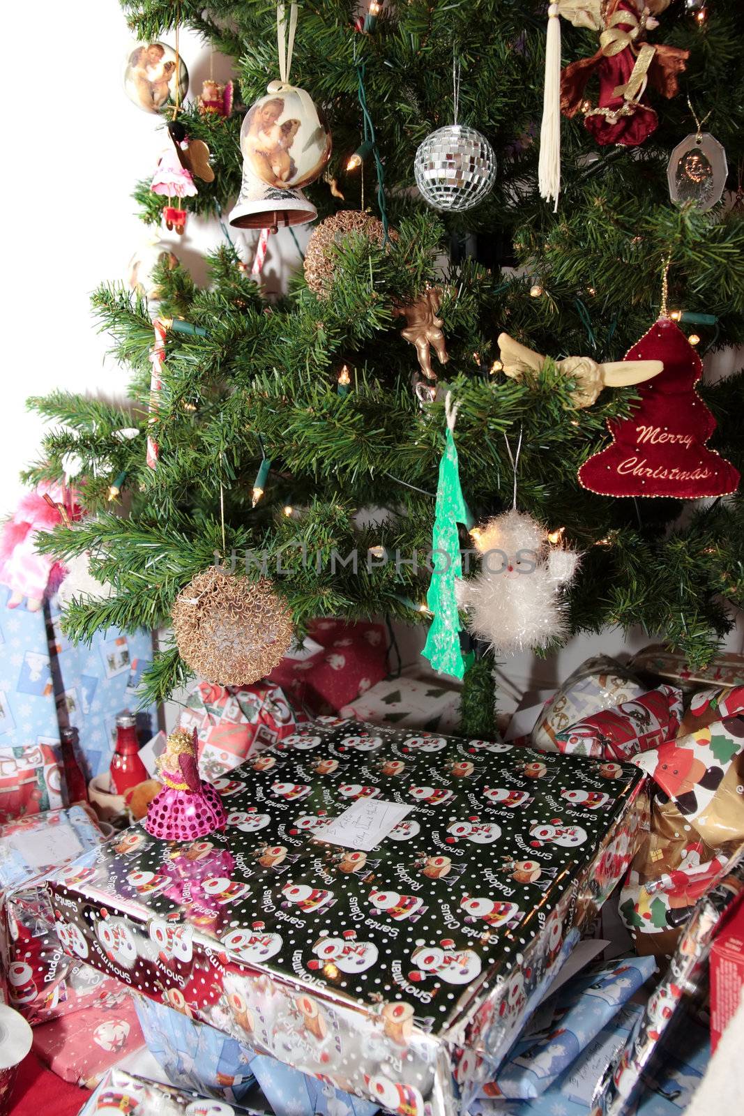 christmas tree decorations hanging from the tree with wrapped presents underneath