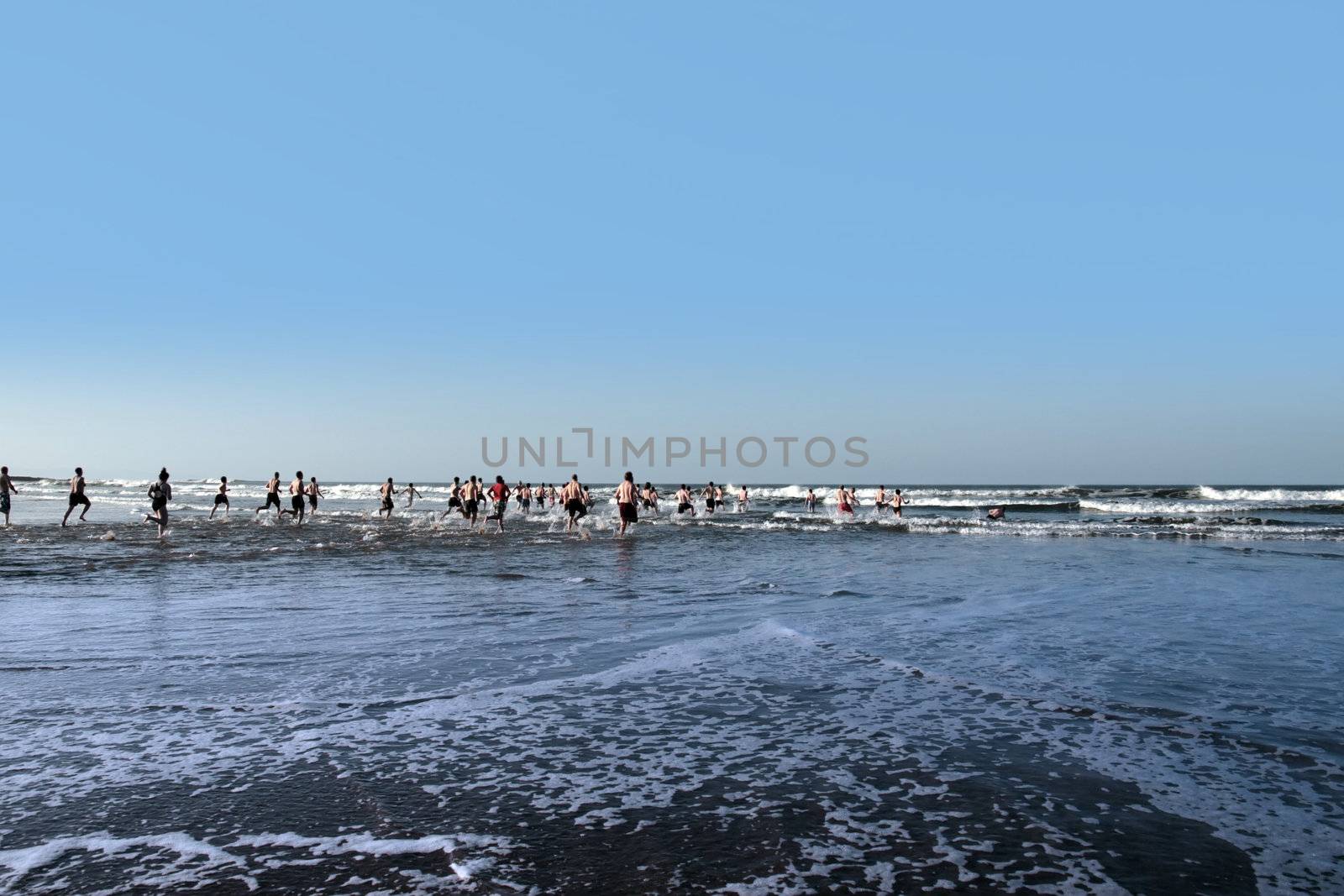people some dressed in santa hats doing a christmas swim for charity
