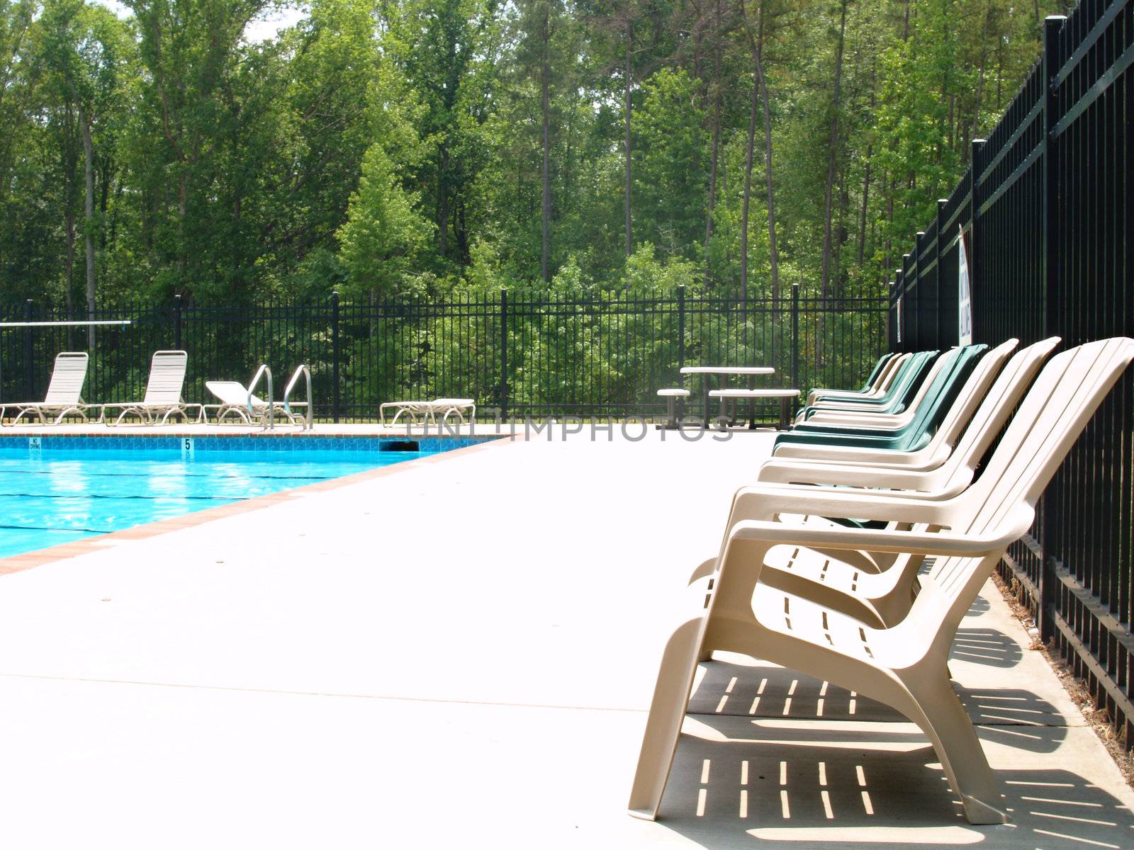 Row of adirondack chairs on a pool deck