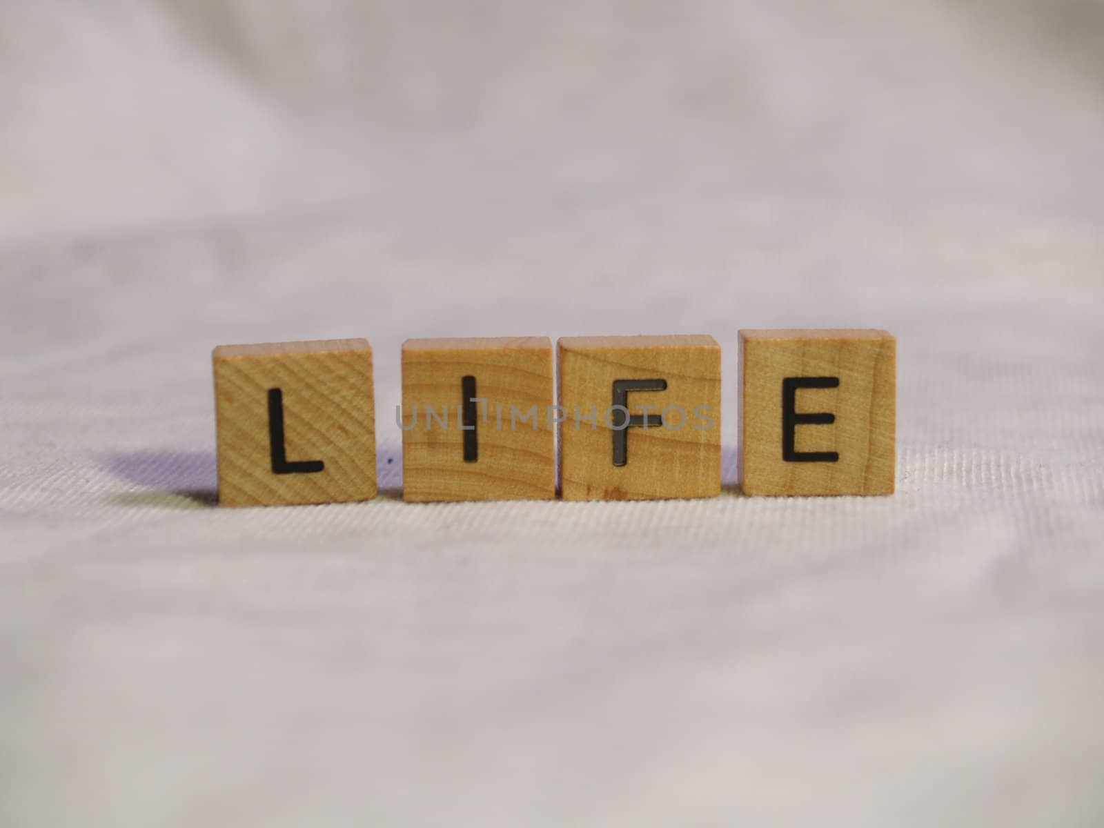 The word LIFE spelled out with wooden tiles