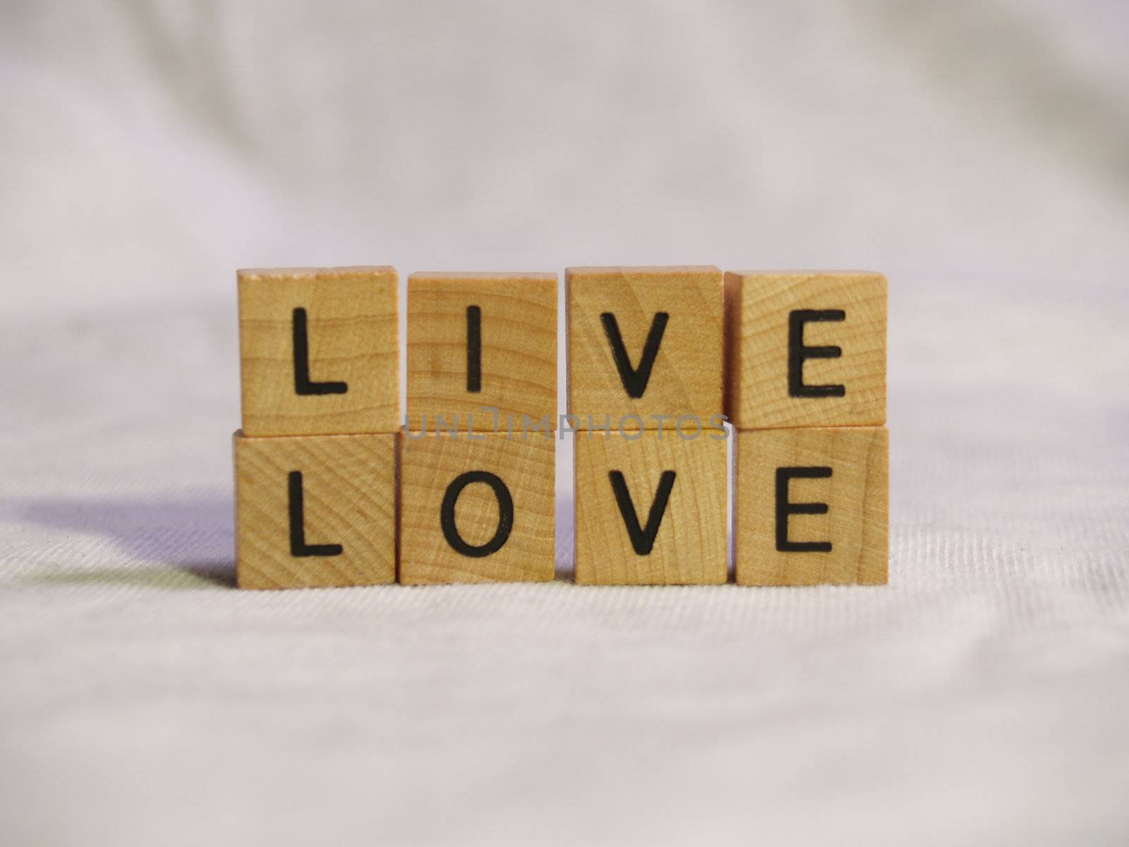 The words LIVE and LOVE spelled out with wooden tiles