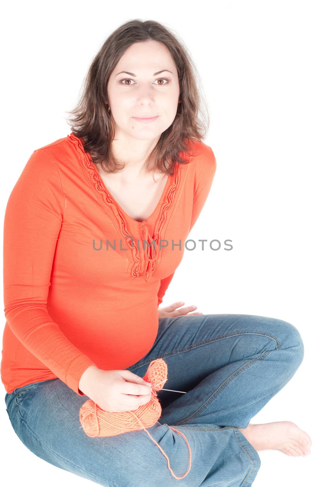 Portrait of pretty pregnant woman knitting, isolated on white