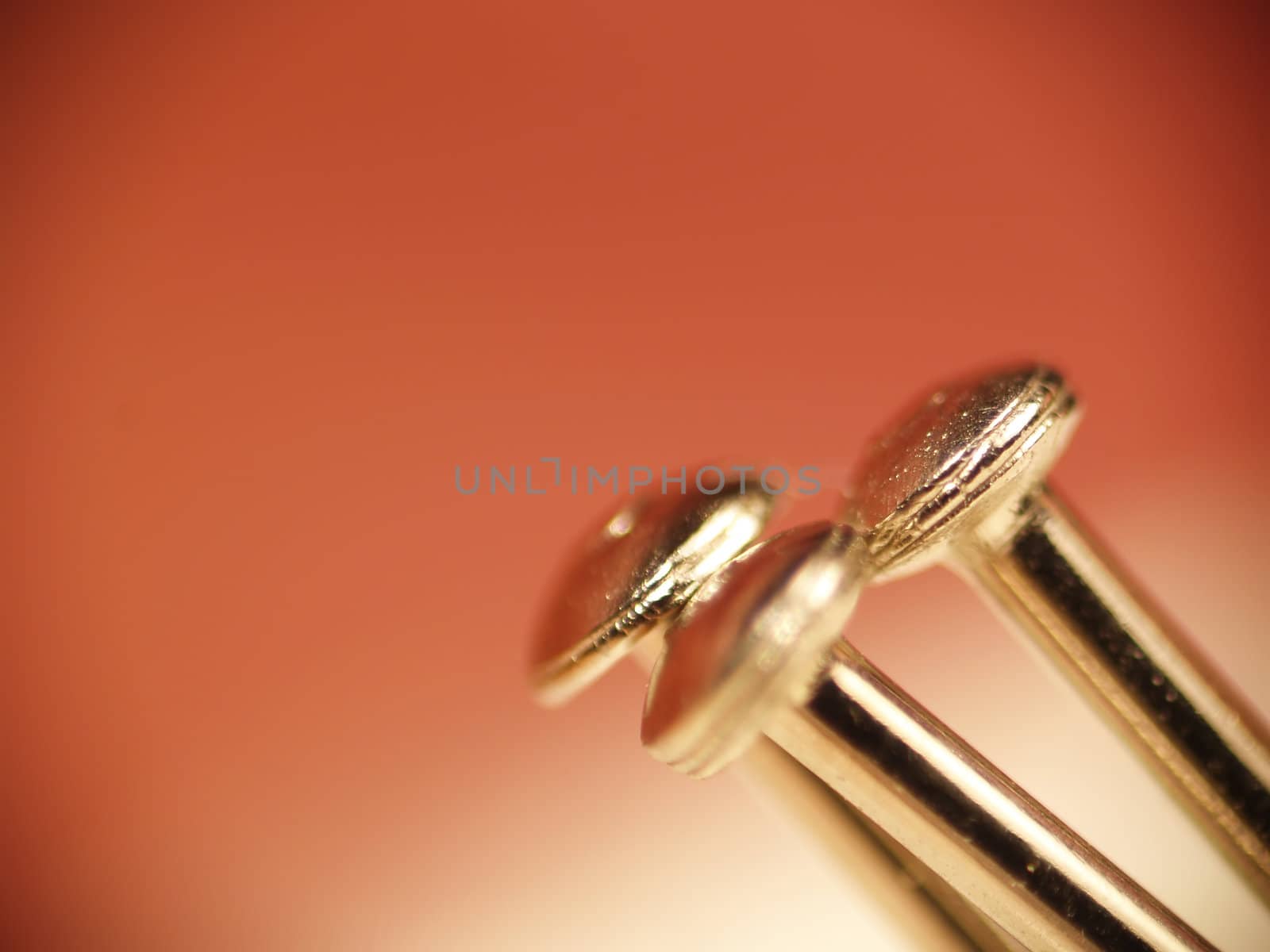 Macro of three sewing pin heads