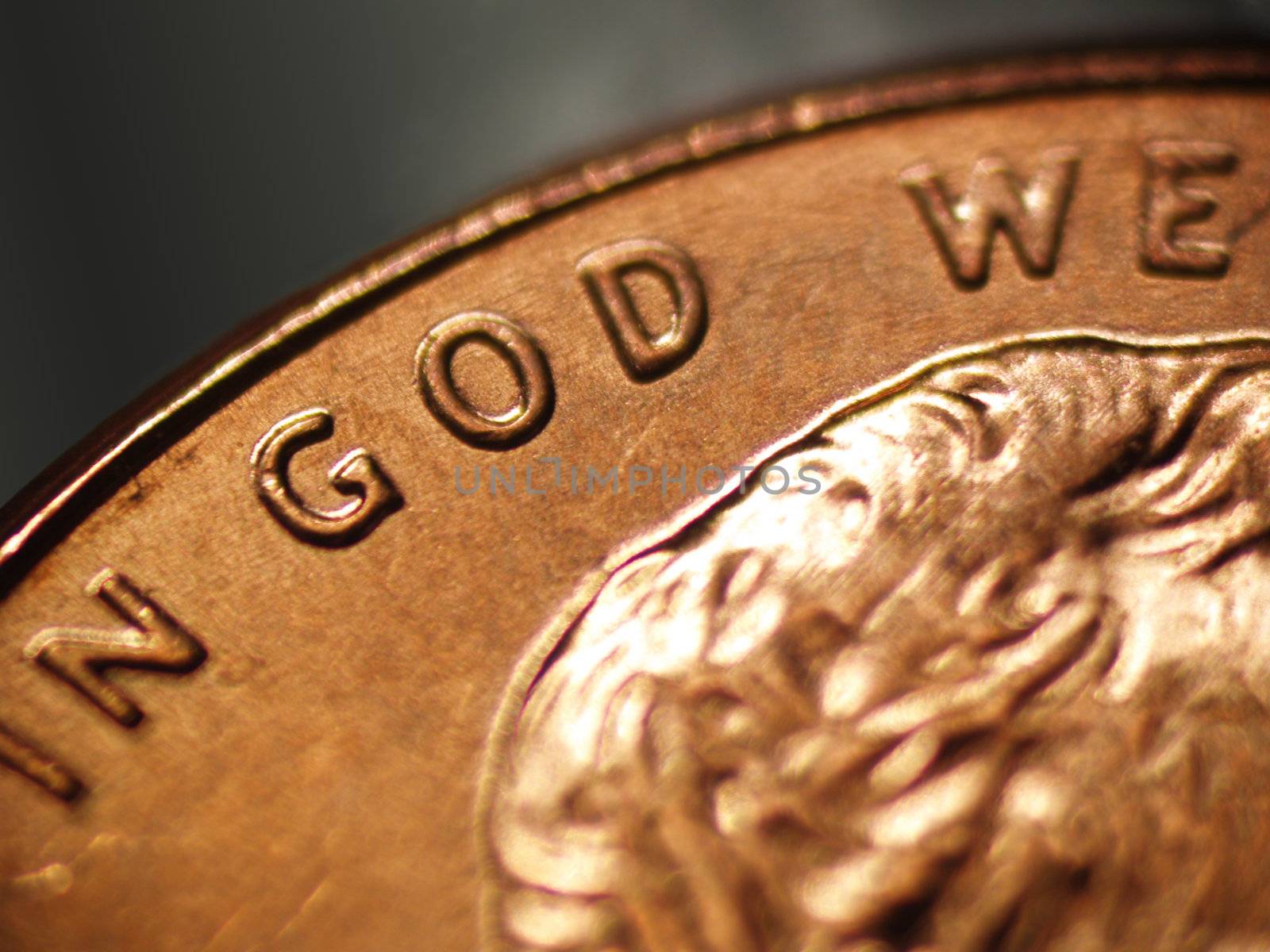 Macro of a penny showing the words "IN GOD WE"