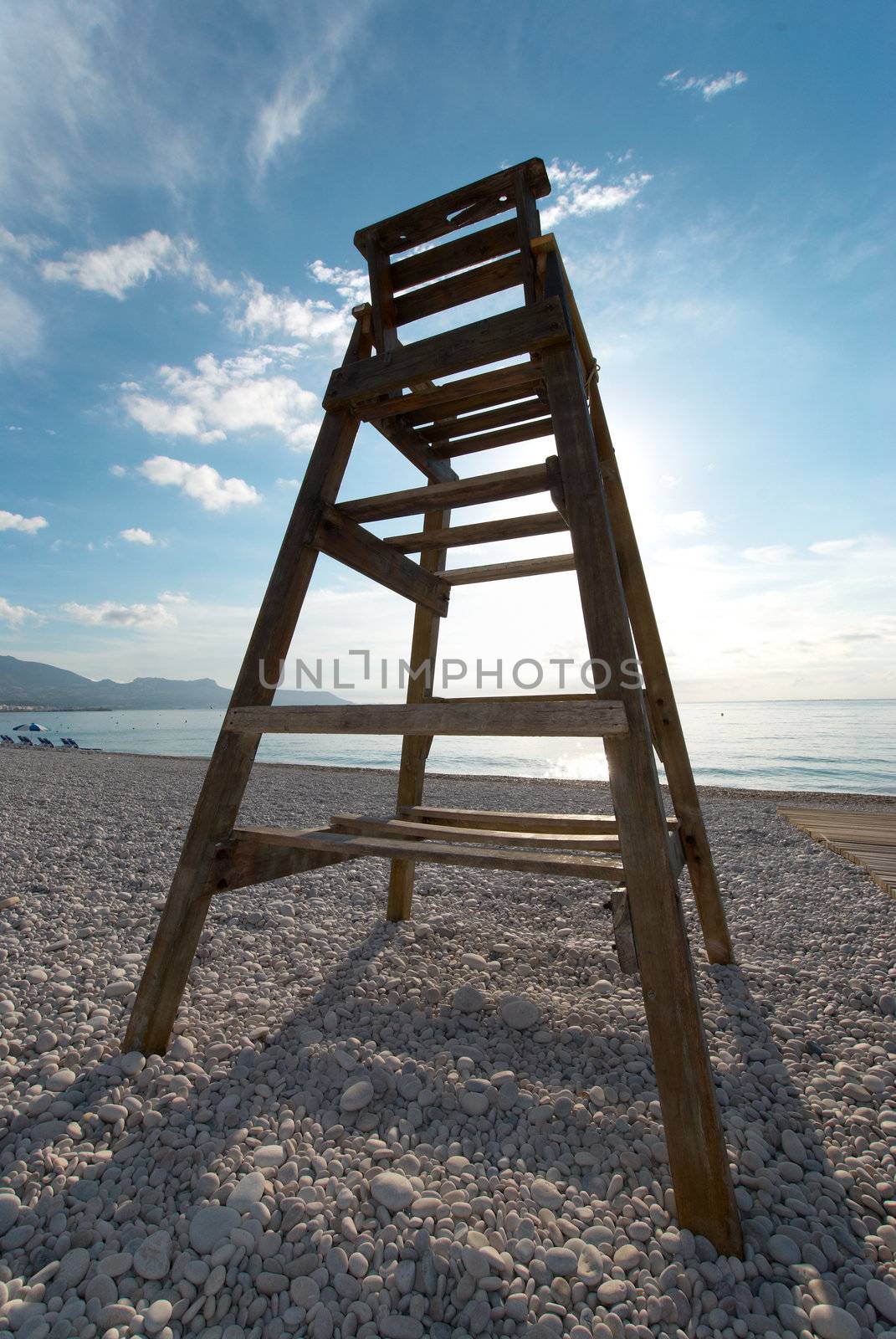 Wooden life guard high seat on a pebble beach