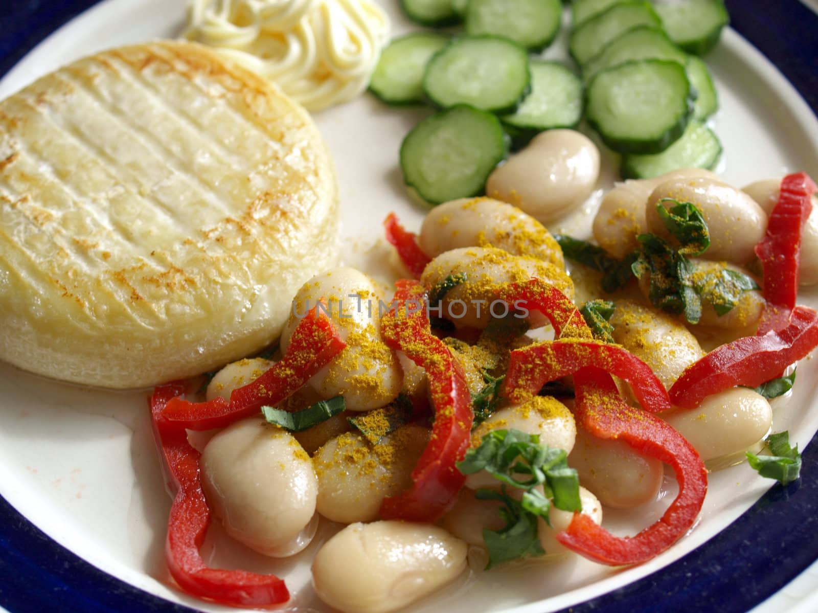 Vegetarian main dish including cheese, mayonnaise, curry beans, peppers and cucumbers