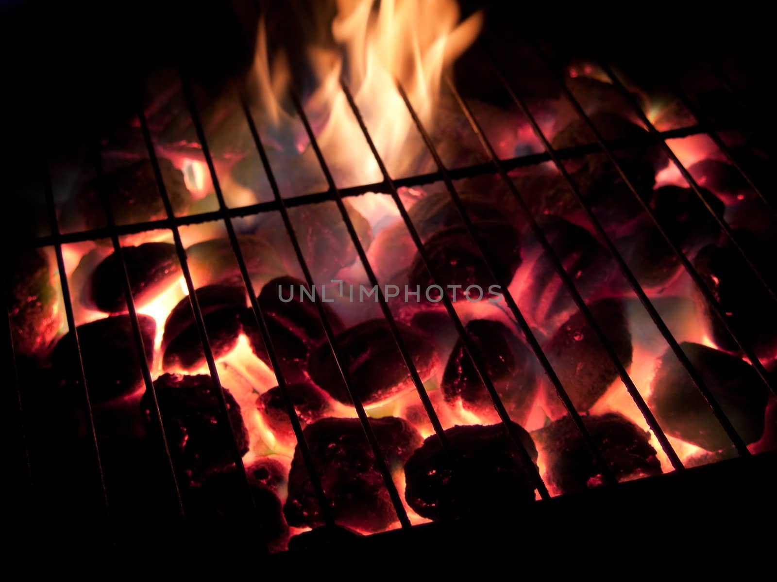 Long exposures of coals buring underneath a grill.