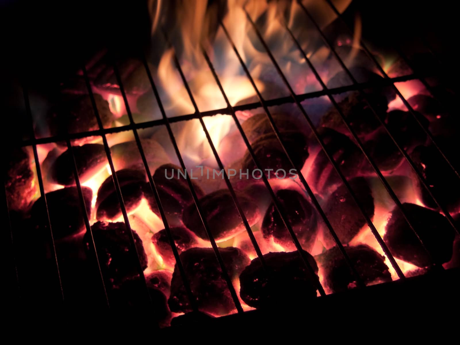 Long exposures of coals buring underneath a grill.