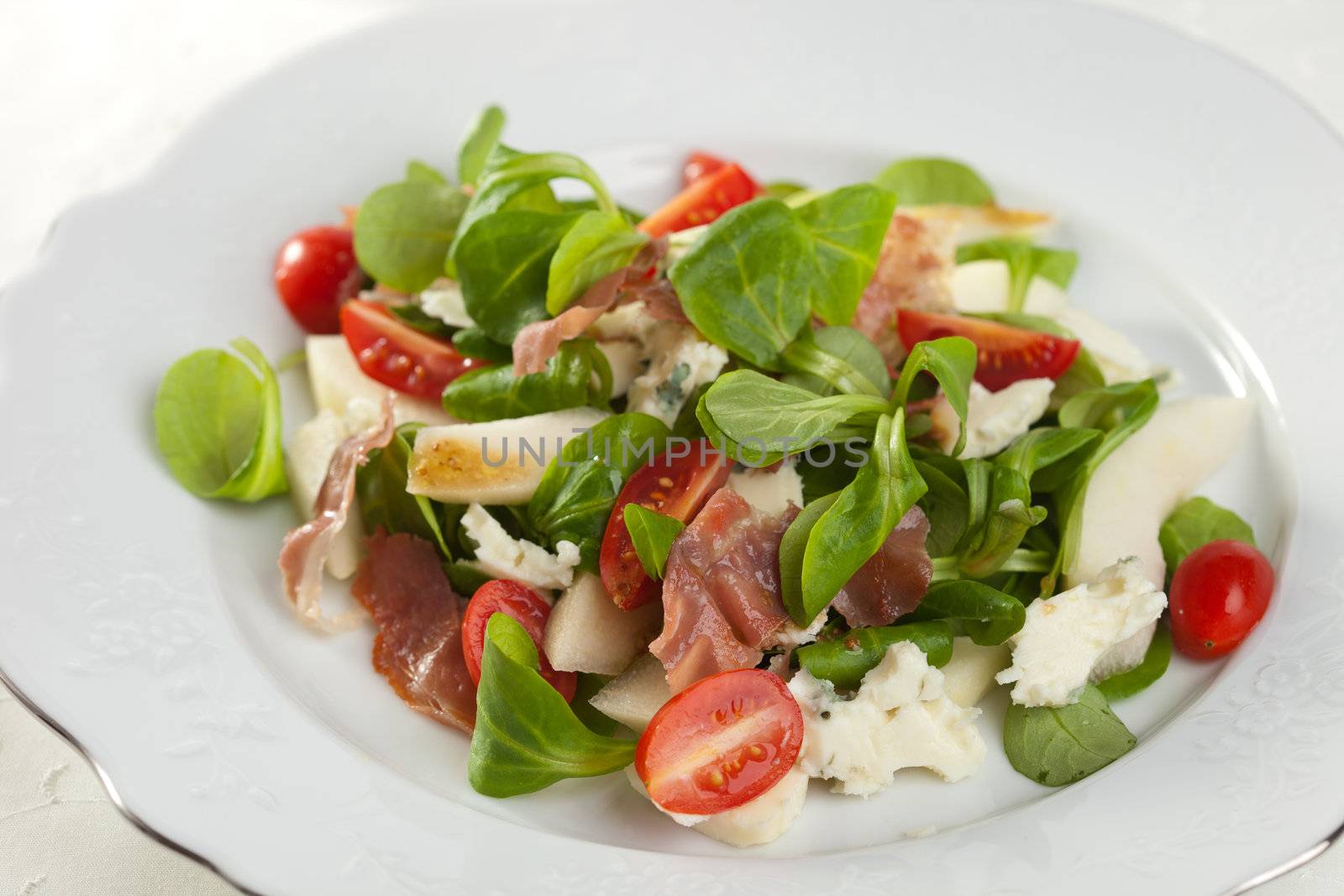 Delicious salad with fresh greens, tomatoes, roquefort and pear