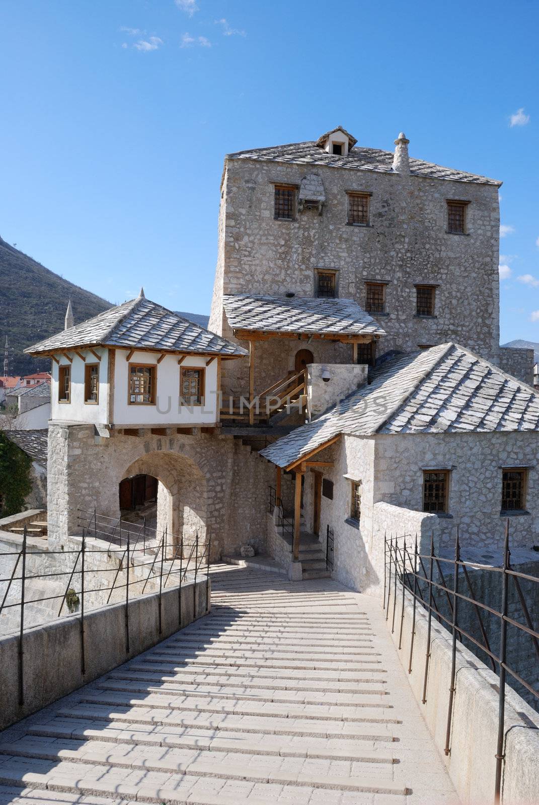 View from the Old Bridge of the west tower and gate in Mostar old town on a sunny day.