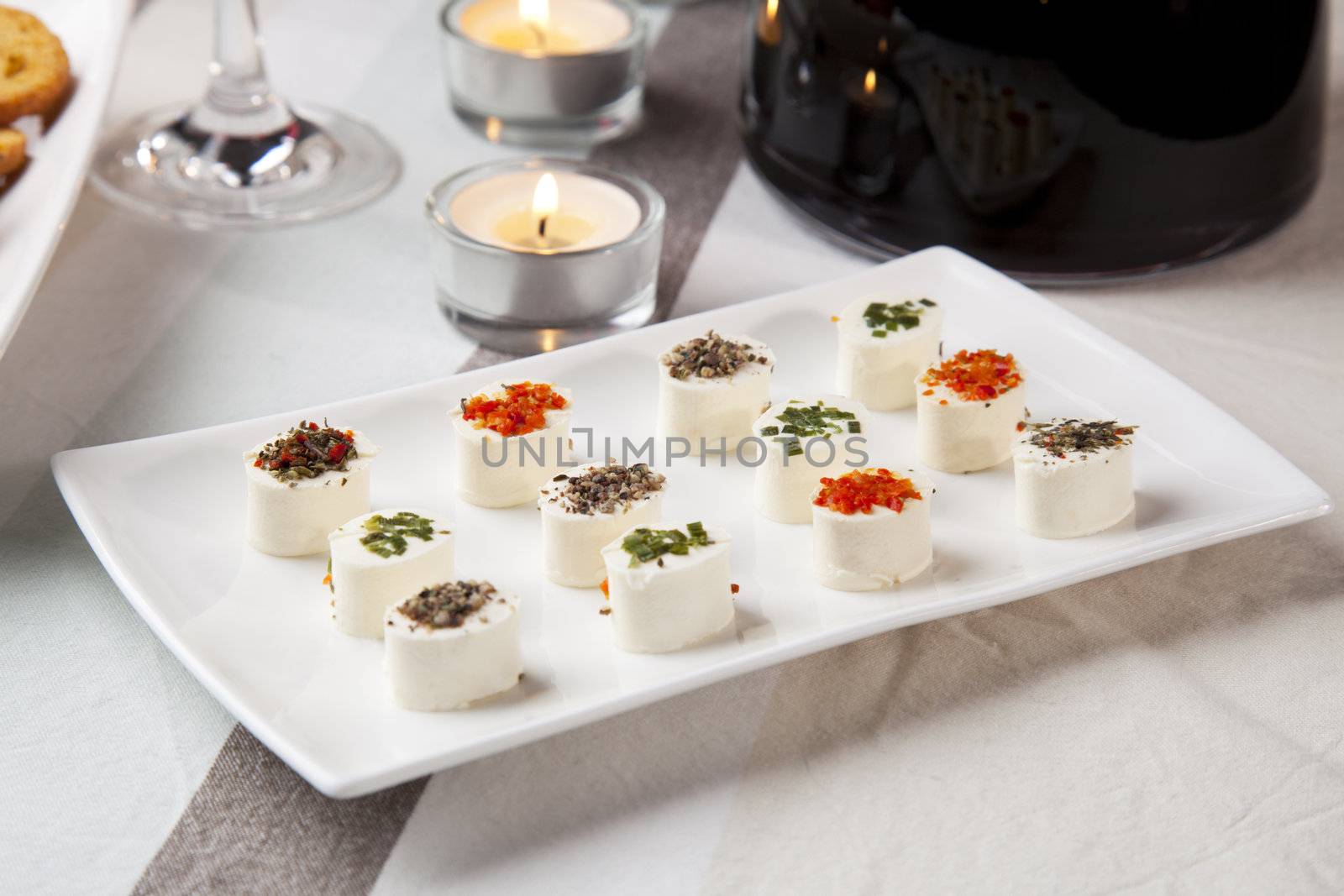 Cheese appetizers on table with wine and candles.
