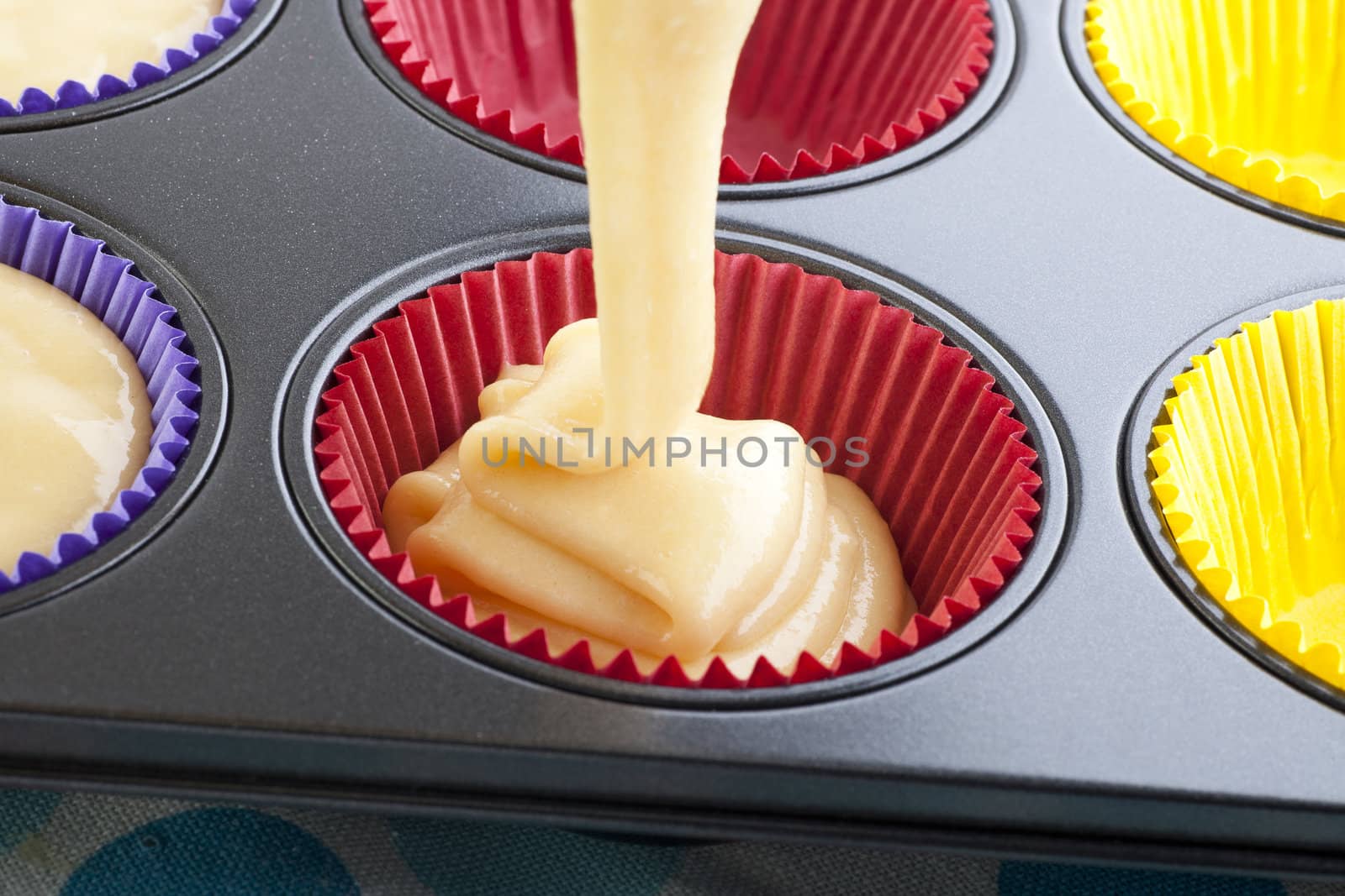 Batter being poured into muffin pan.