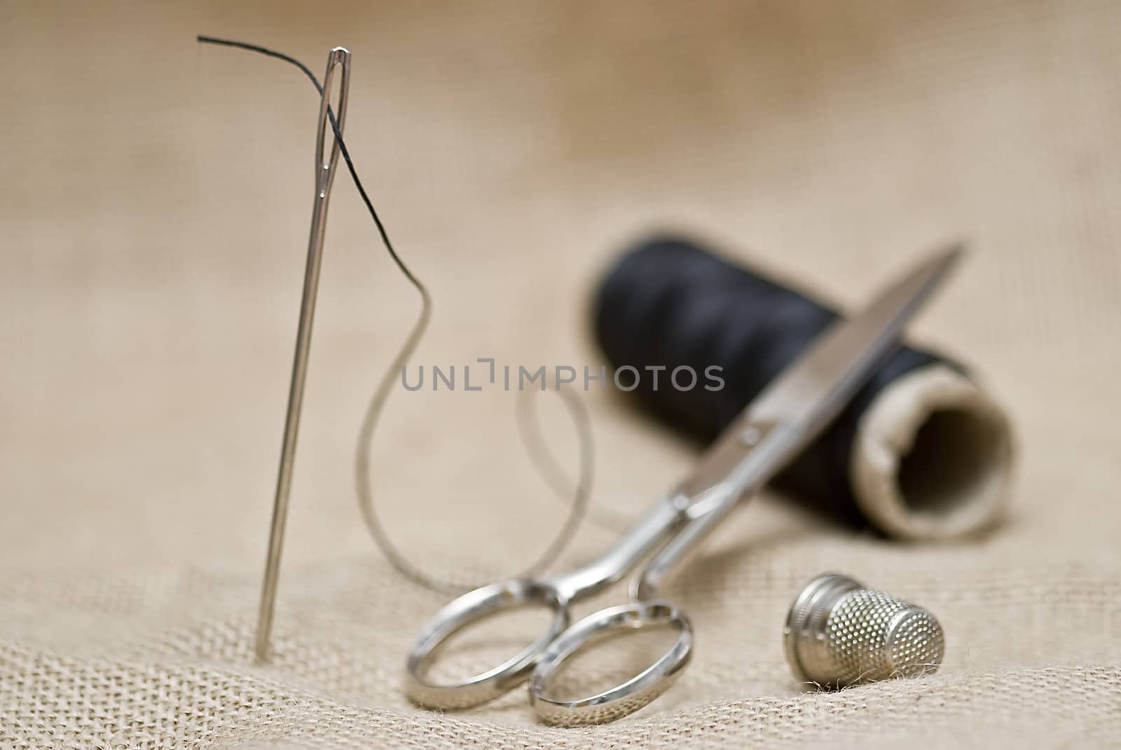 Utensils for sewing on a piece of burlap.