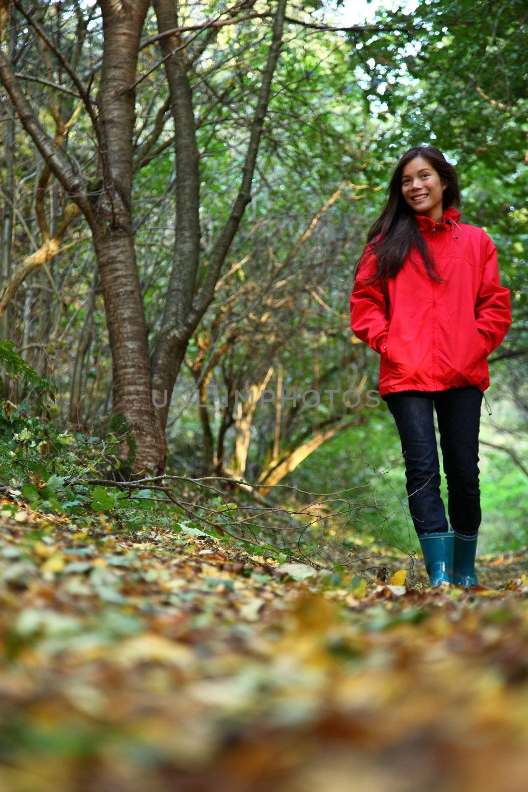 Autumn woman. Beautiful woman walking in the forest on a fall day.