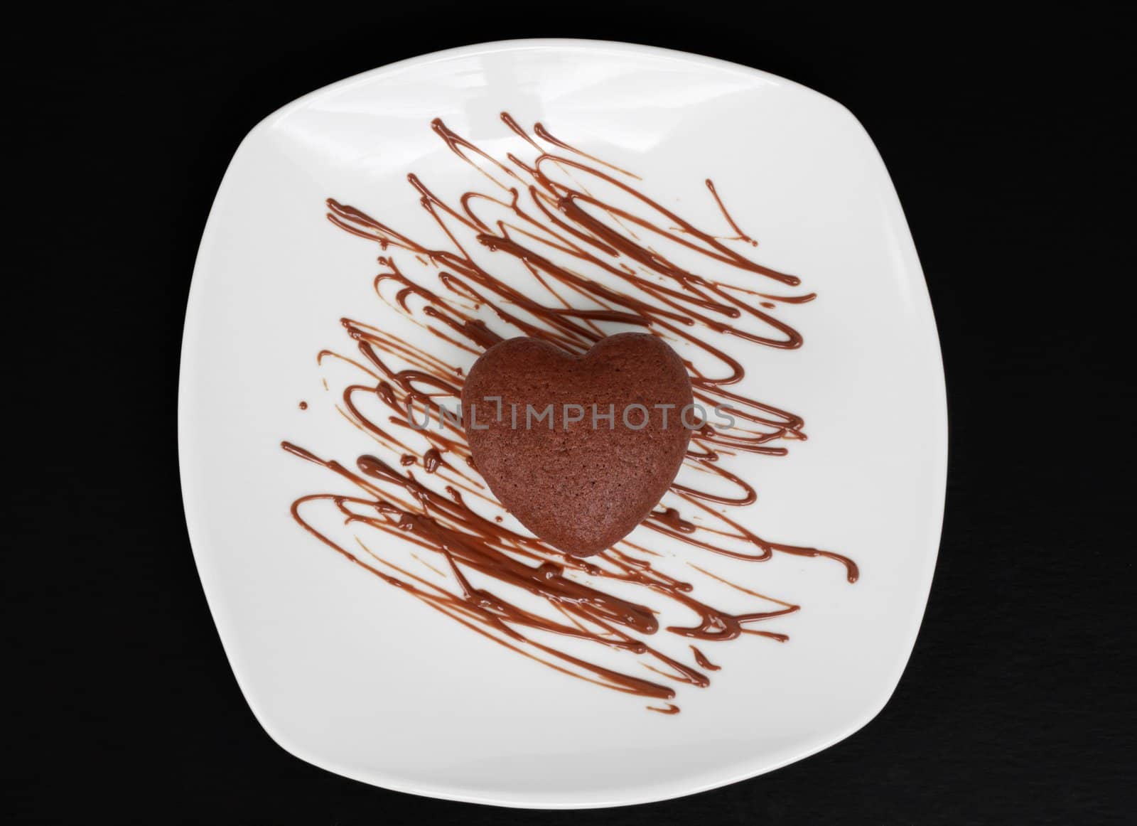 small chocolate cake in white plate, heart shape