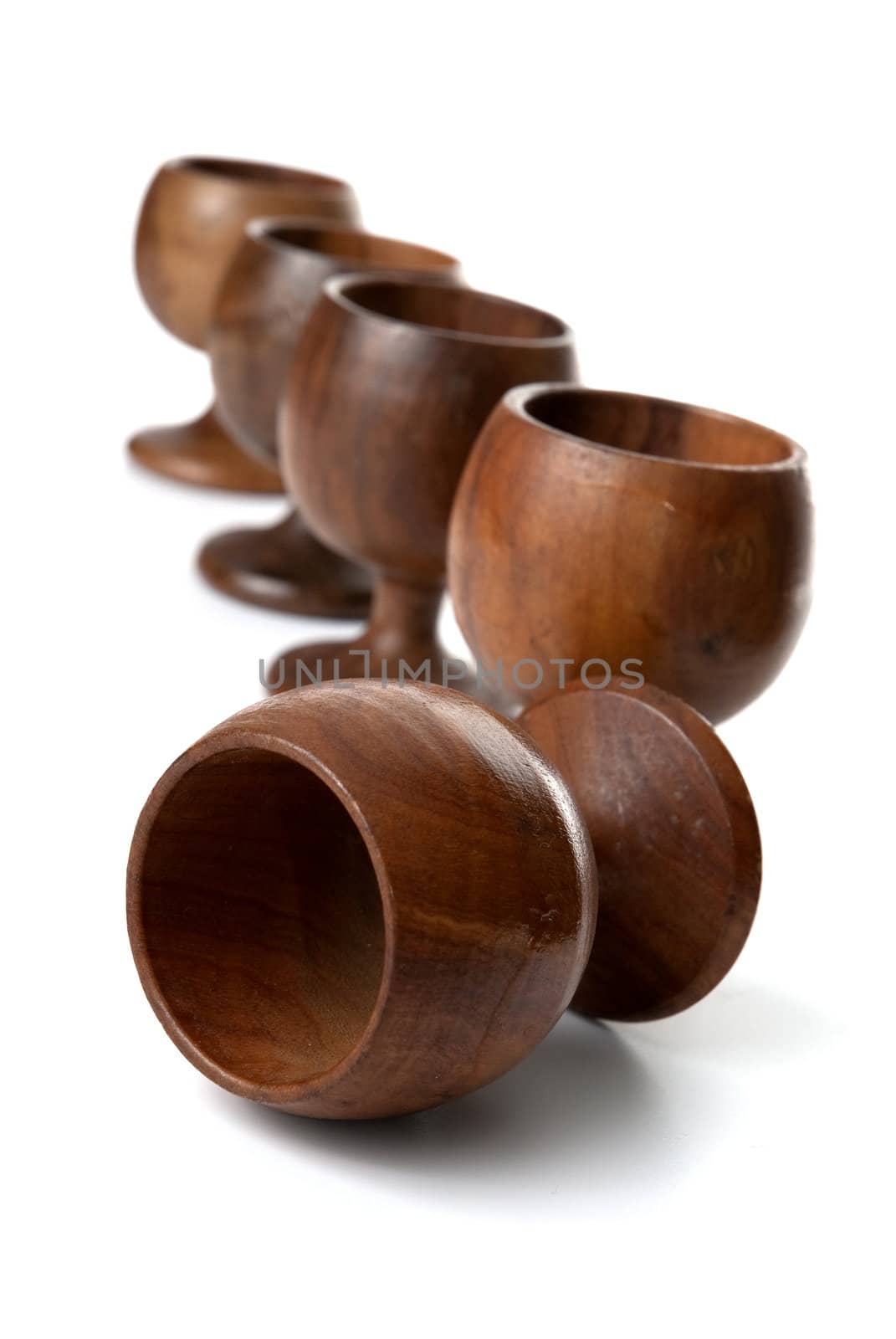 Wooden cups aligned isolated on white background.