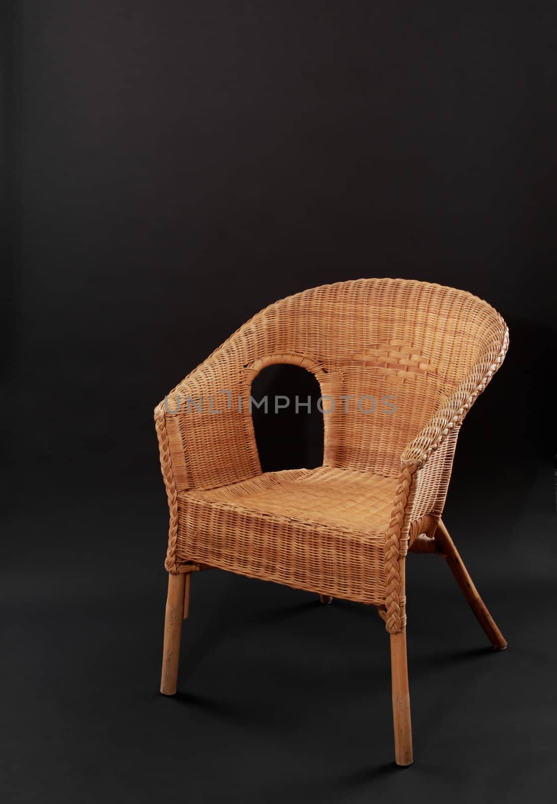 wicker chair over black background