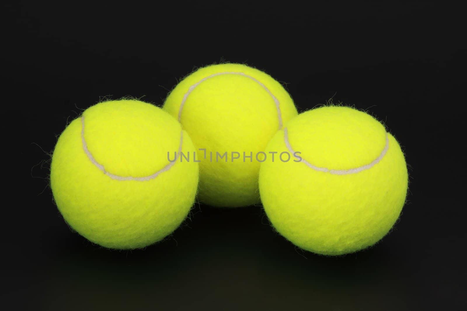 three yellow new tennis ball, black background