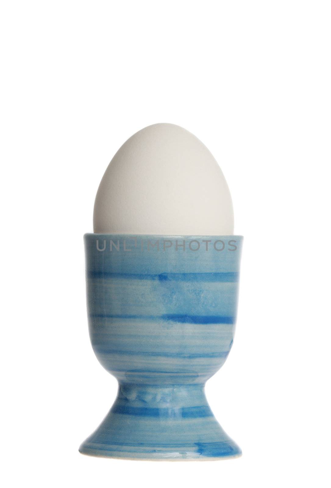 egg in blue eggcup, isolated on white