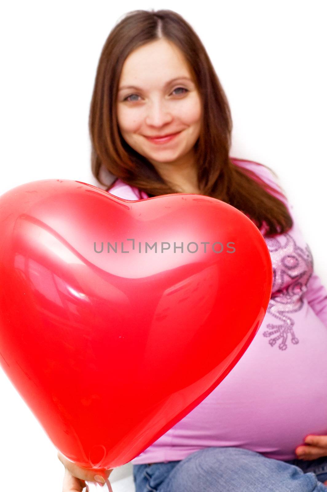 Pregnant woman with heart shaped balloon, focus on balloon