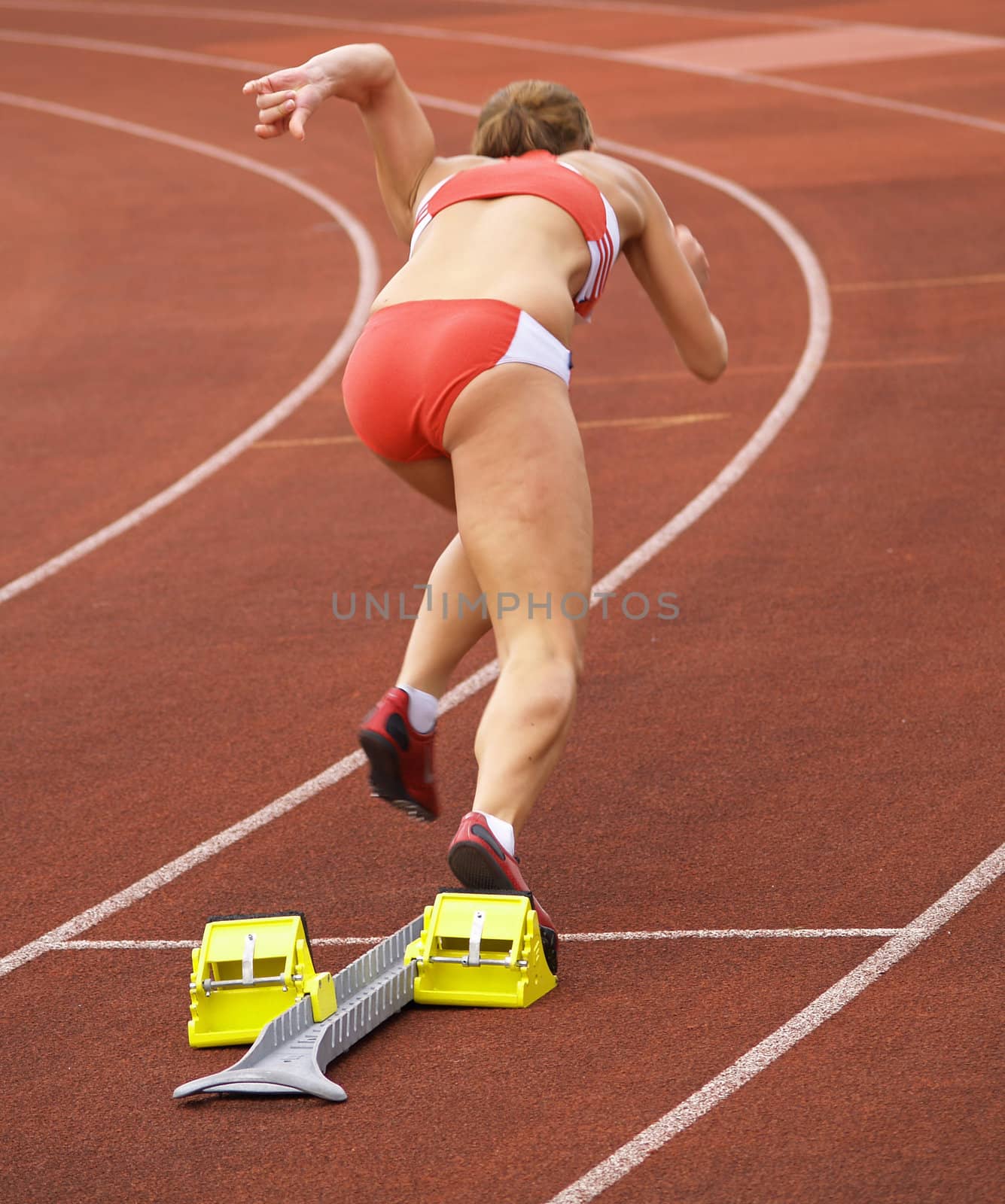 A female athlete runs off the starting block
