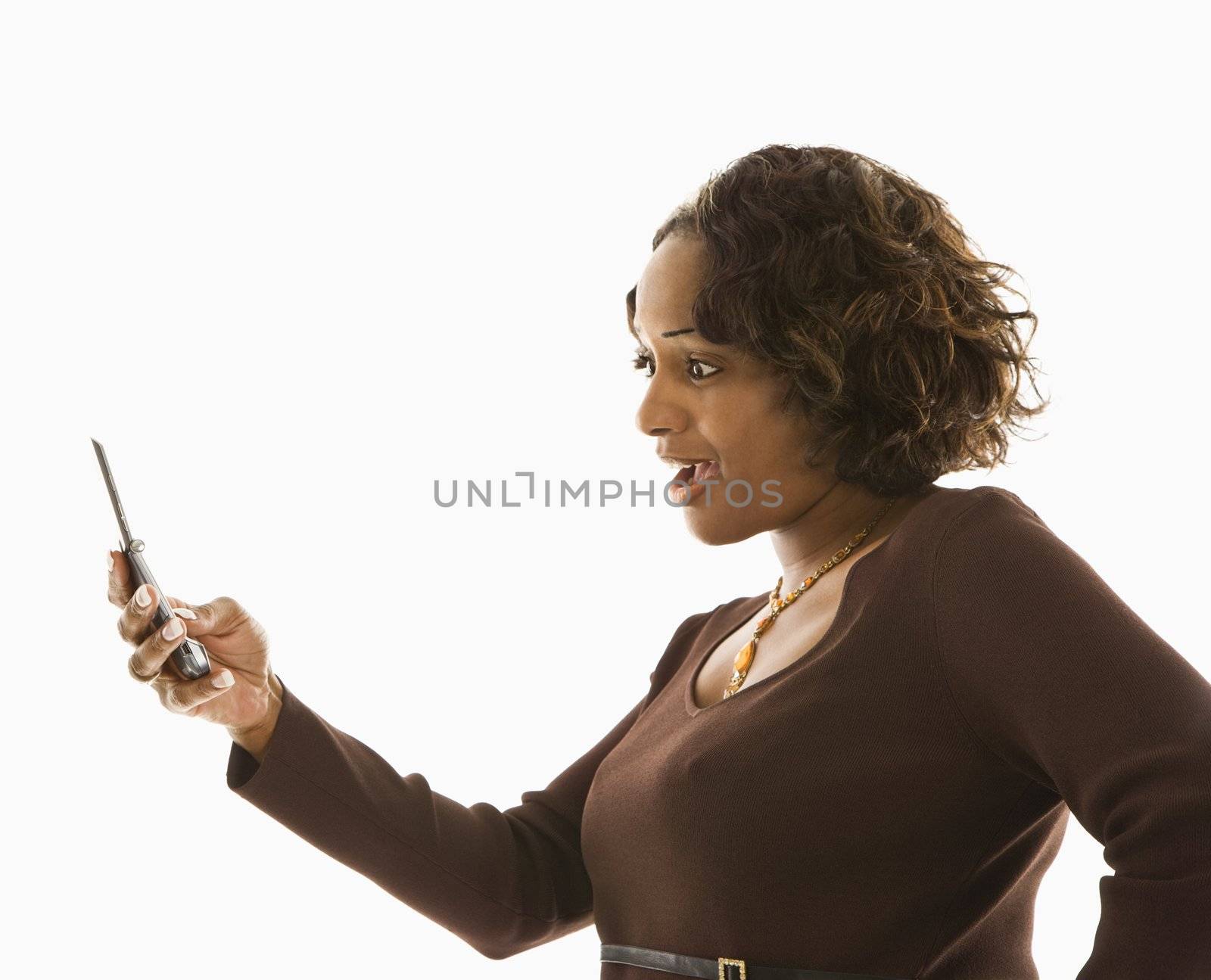 Woman looking at cellphone with shocked expression.