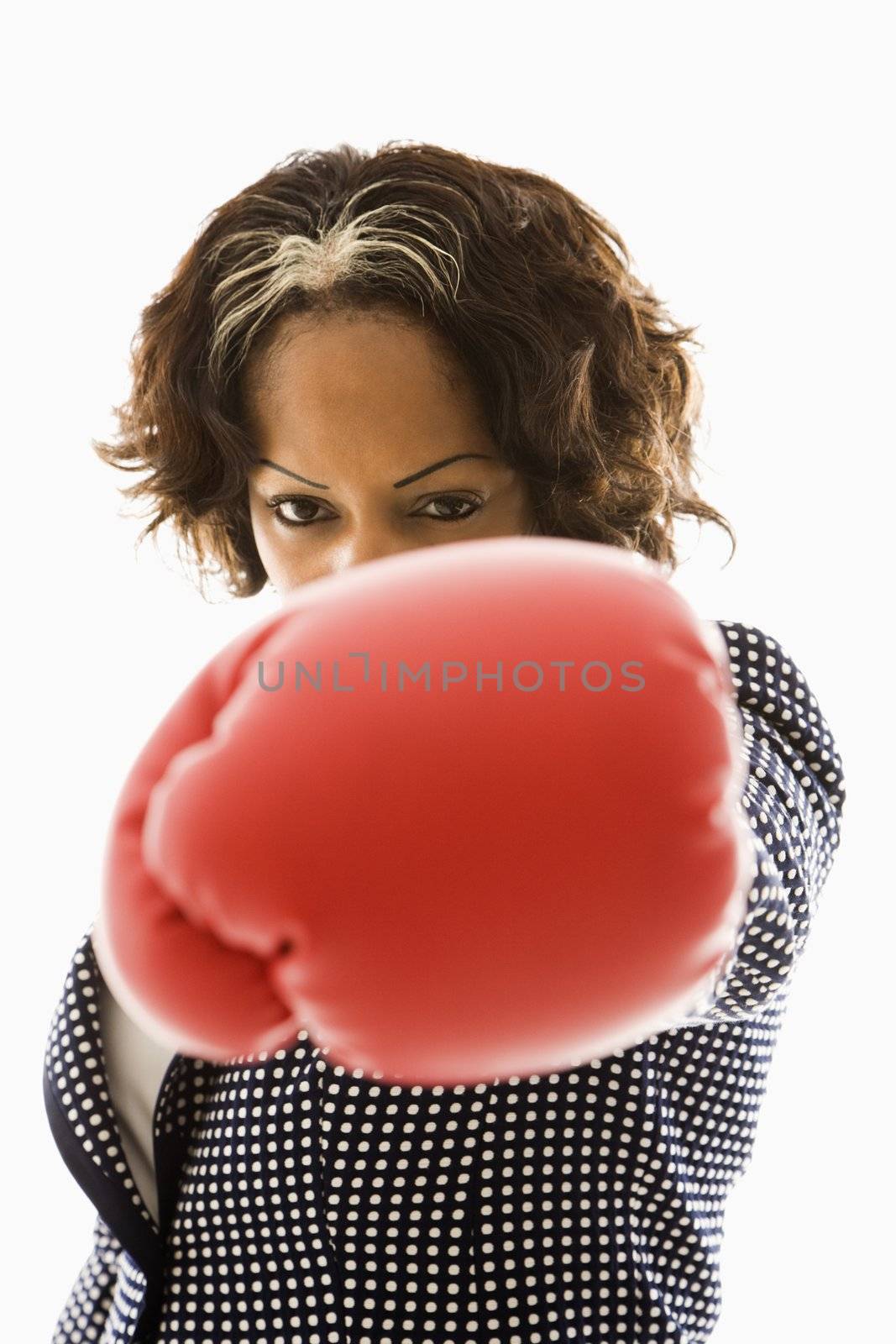 Businesswoman wearing boxing gloves punching.