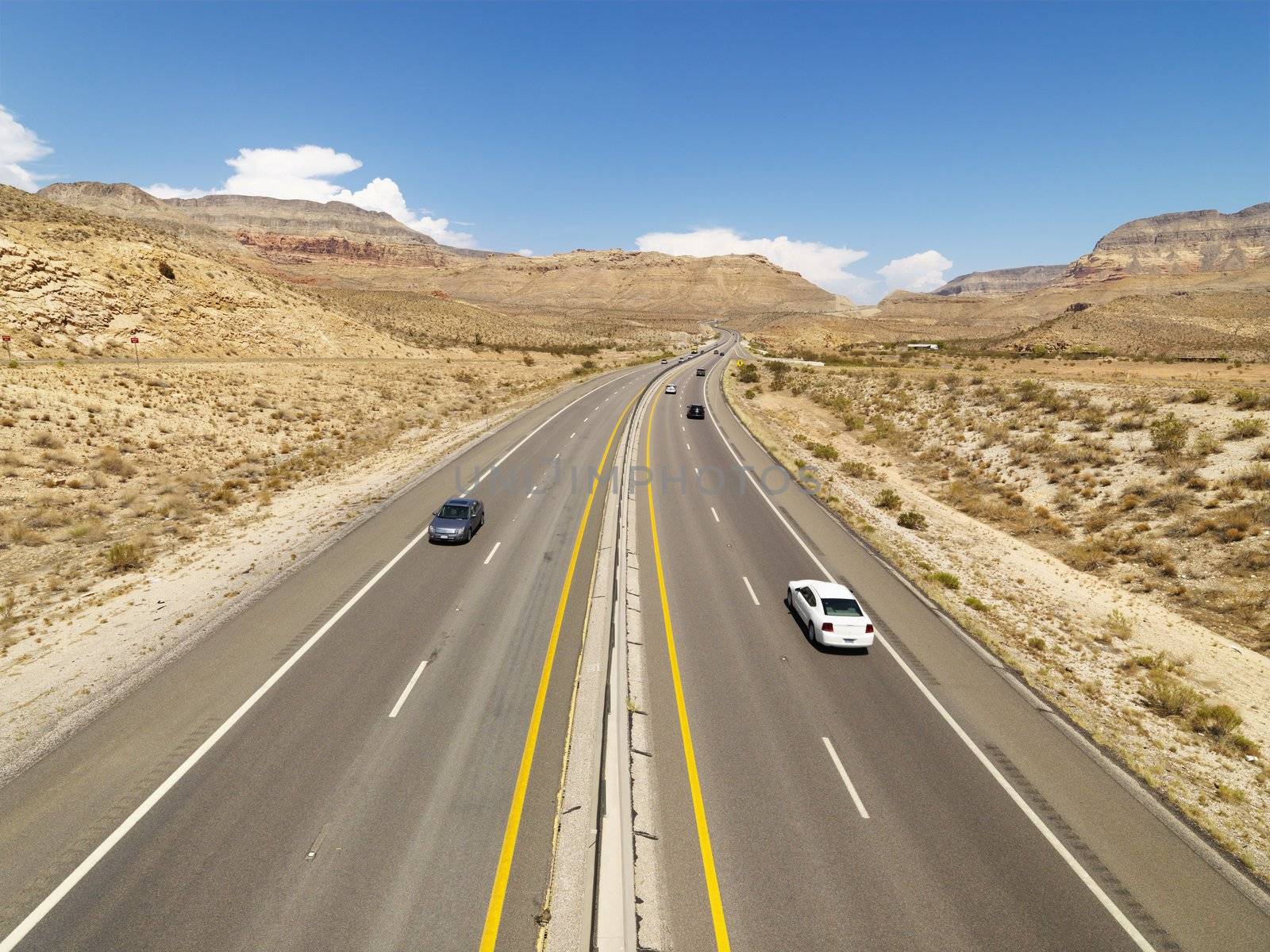 Birds eye view of automobiles on rural desert highway.