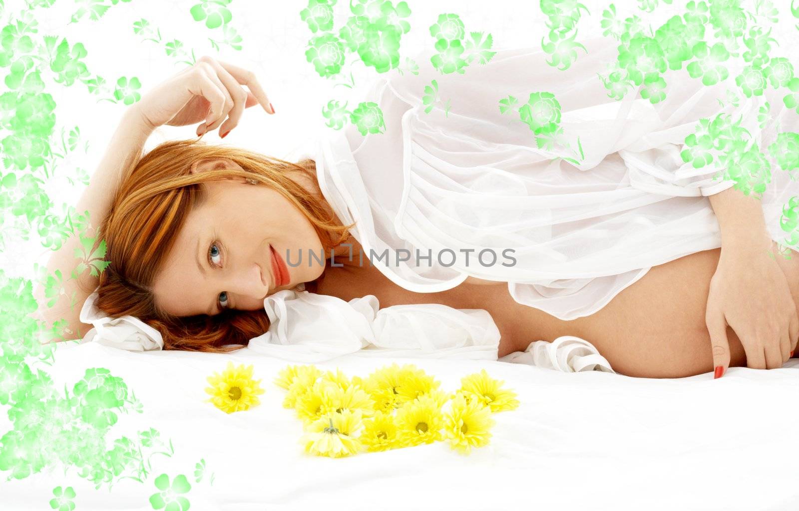 beautiful pregnant woman with flowers in bed