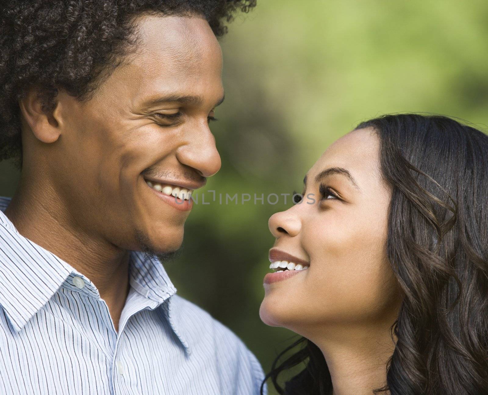 Portrait of smiling couple looking into eachother's eyes.