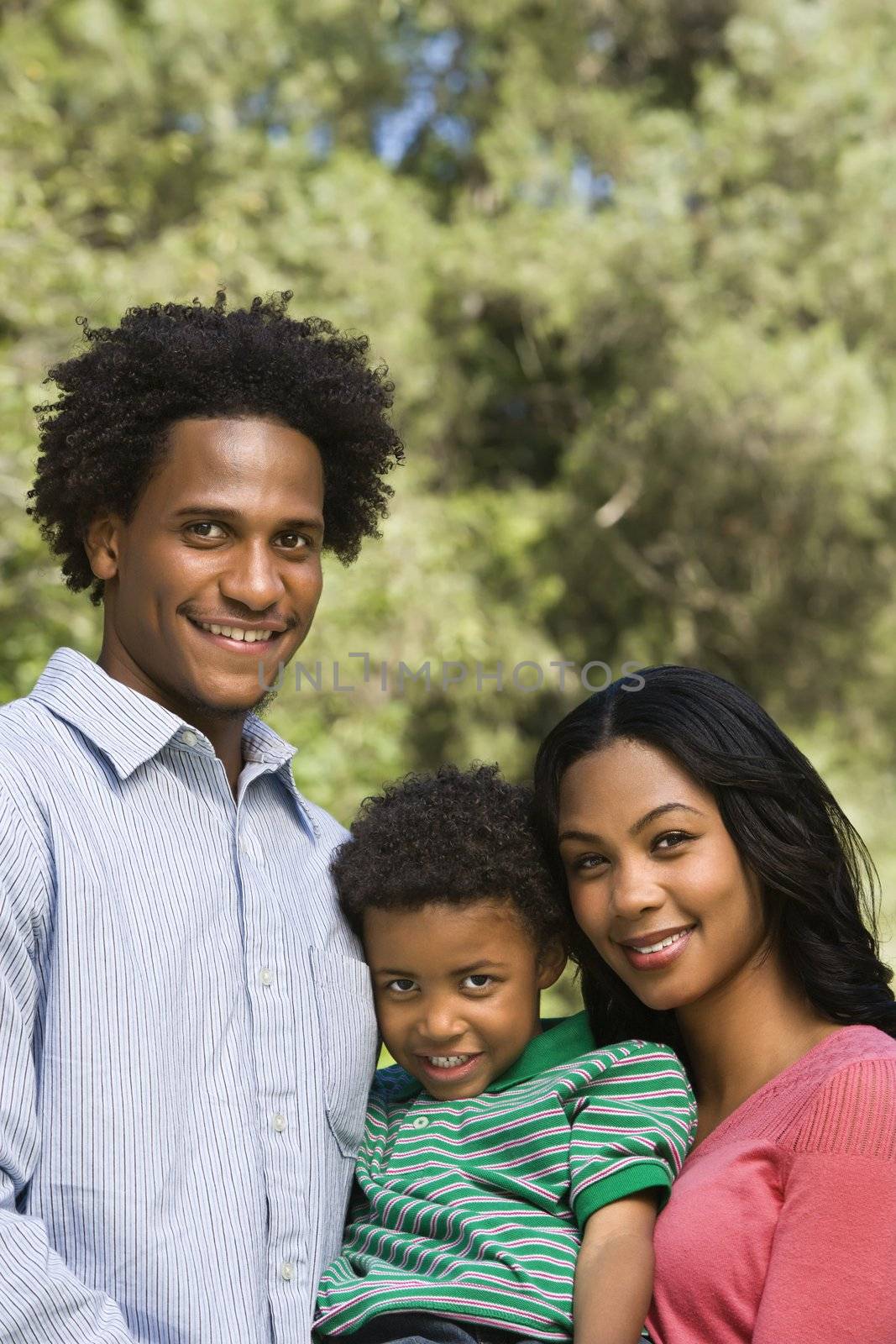 Family portrait of parents and young son smiling.