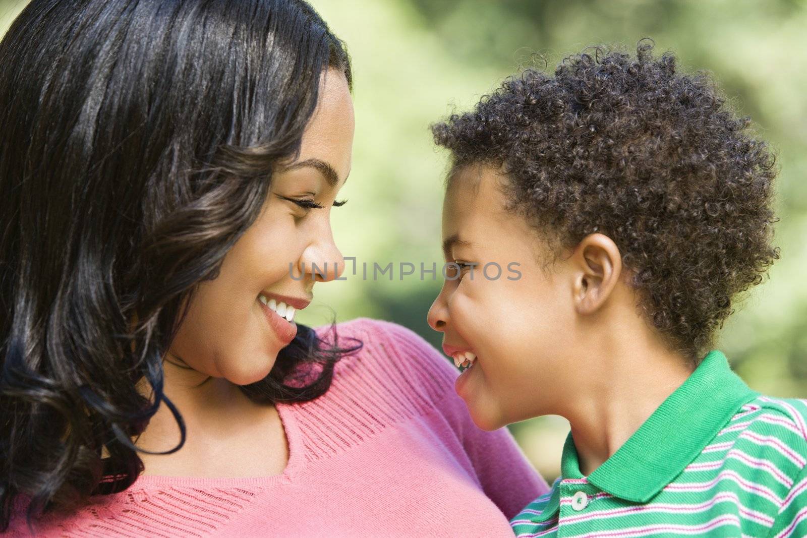 Happy mother holding son smiling at eachother.
