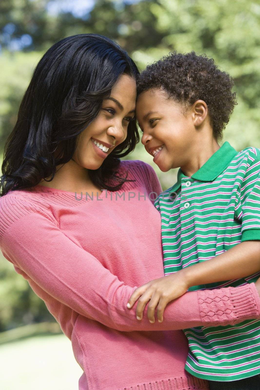 Mother and son with arms around eachother looking at eachother and smiling.