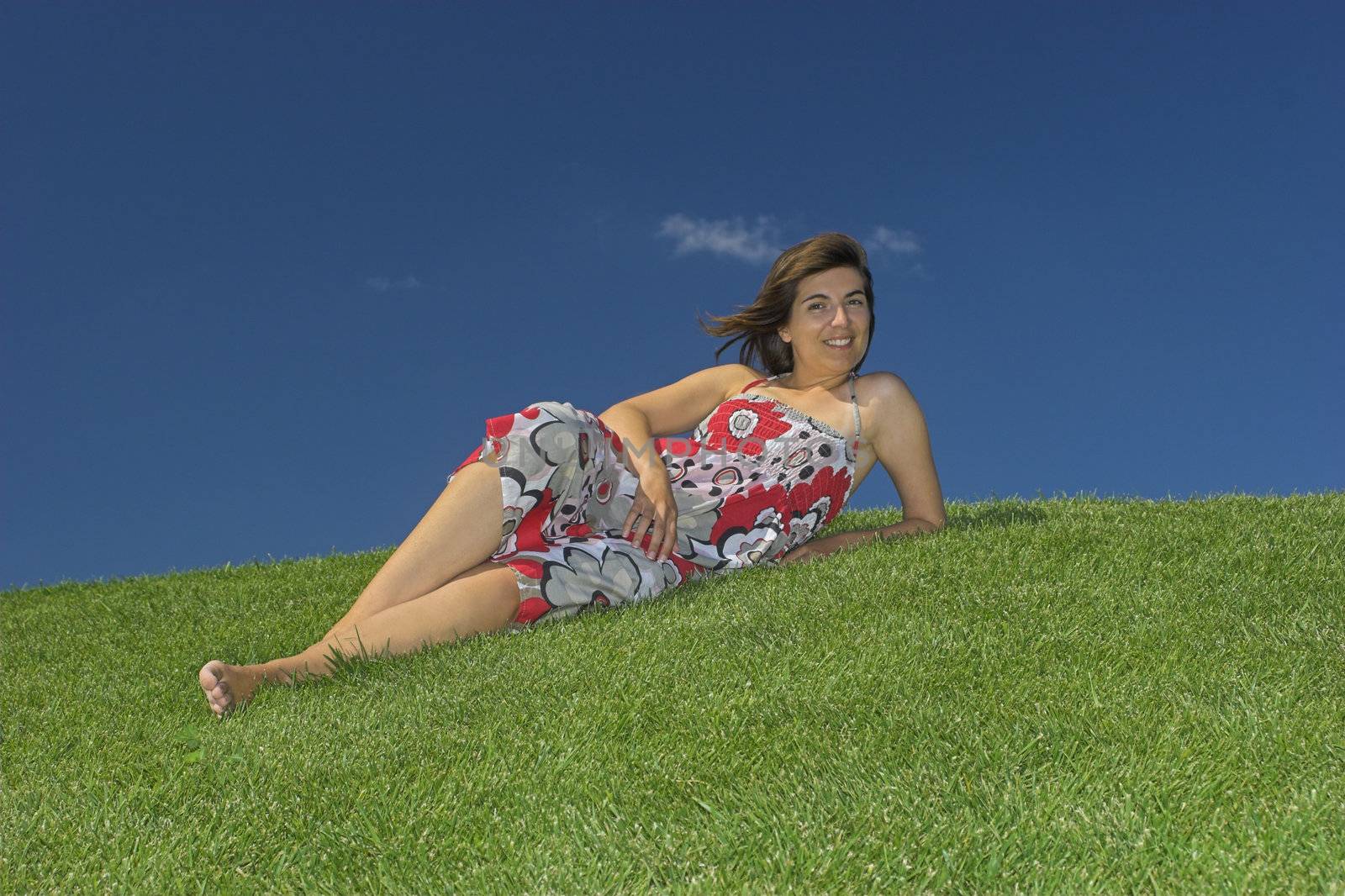 Beautiful woman relaxing on a beautiful green field