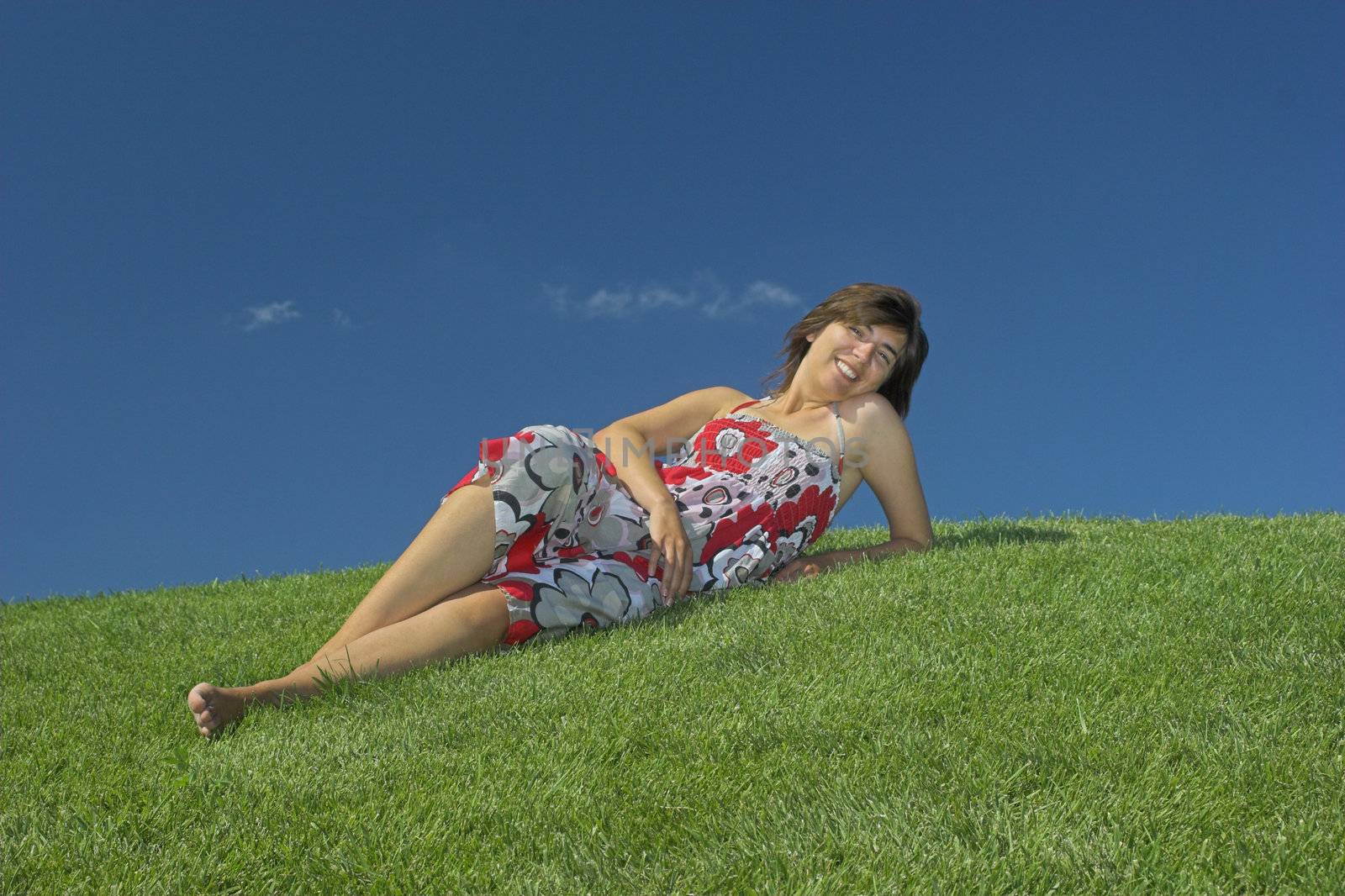 Beautiful woman relaxing on a beautiful green field