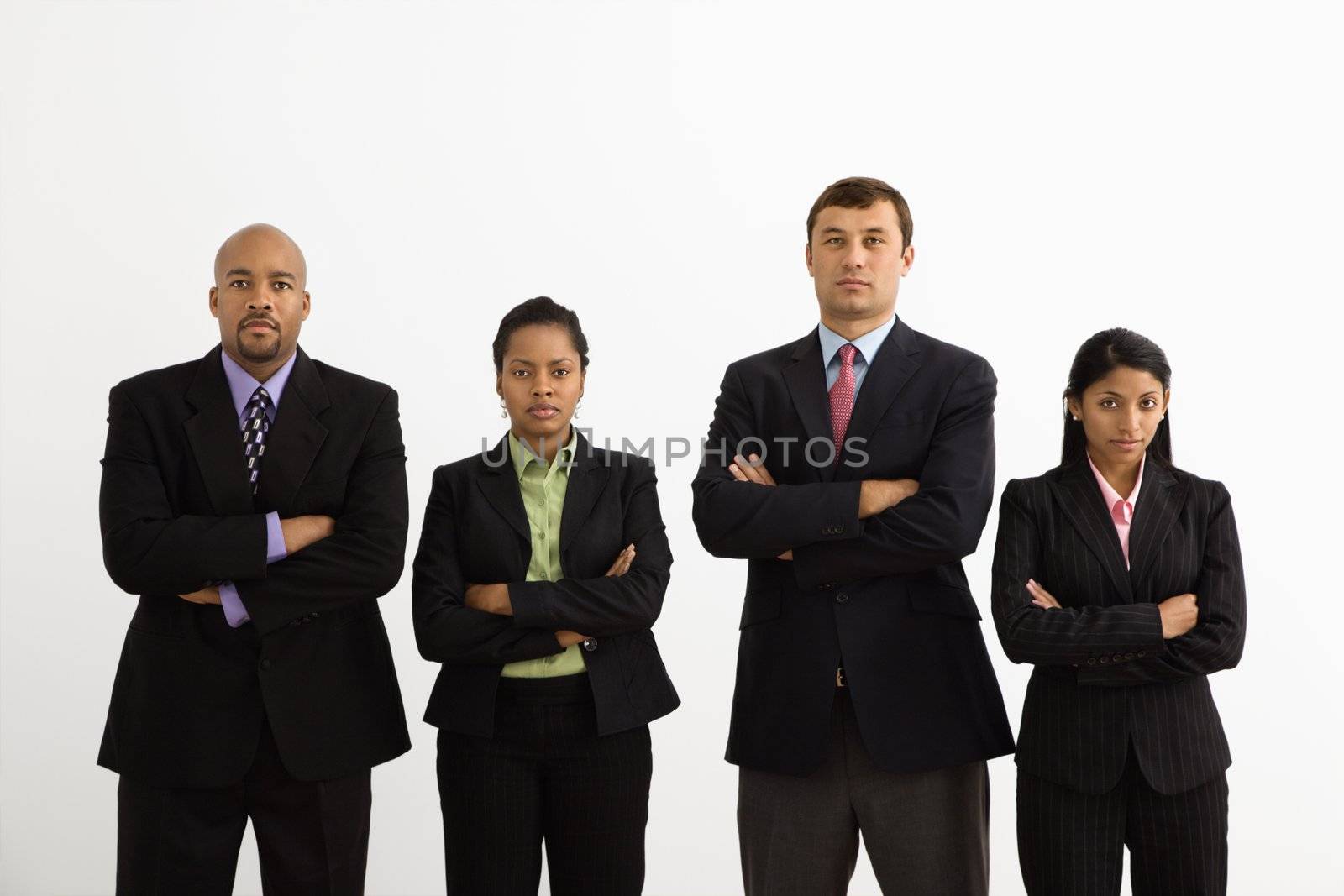 Portrait of businessmen and businesswomen standing with arms crossed looking serious.
