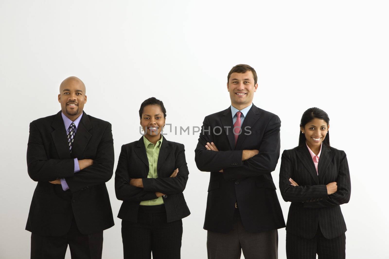 Portrait of businessmen and businesswomen standing smiling with arms crossed.