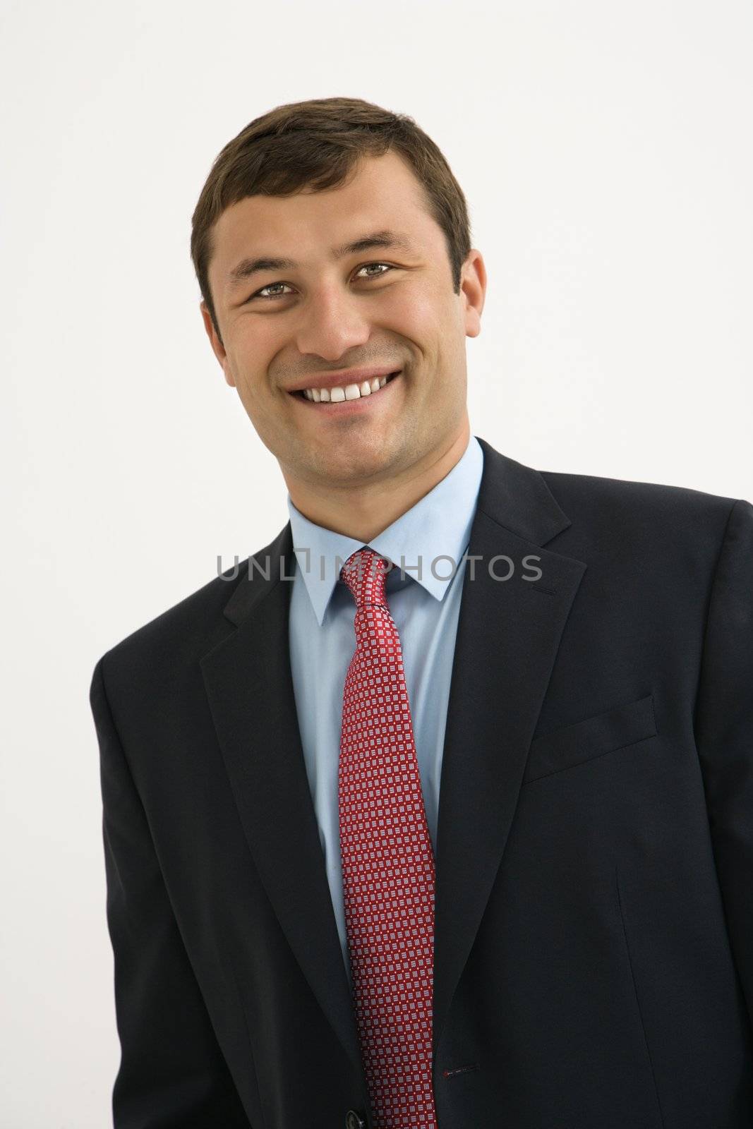 Portrait of smiling businessman against white background.