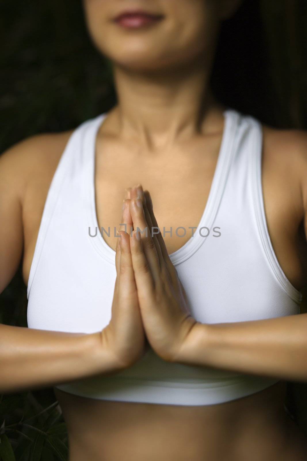 Portrait of Asian American woman in fitness attire standing in yoga position.