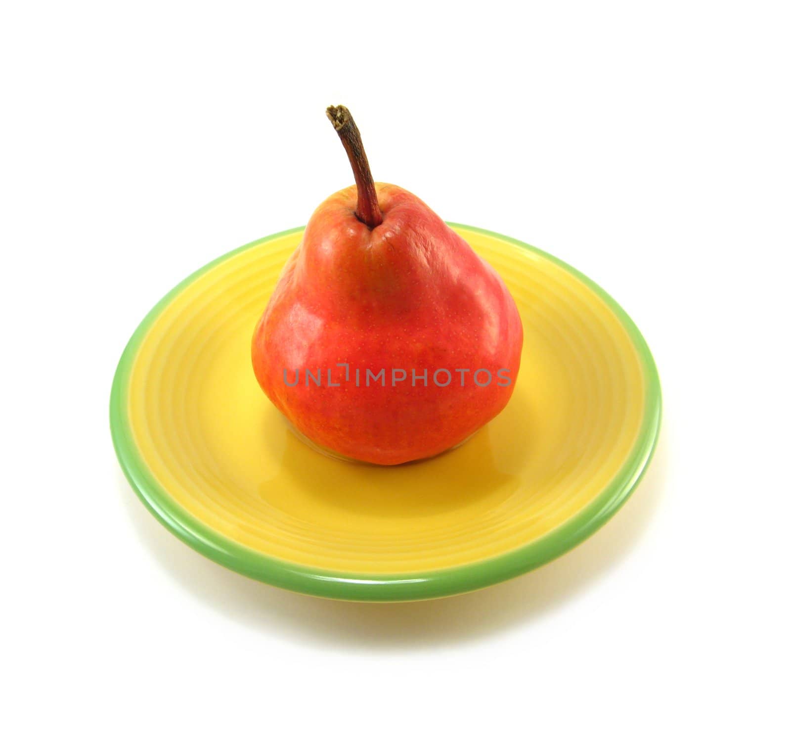 image of a red pear on a yellow plate