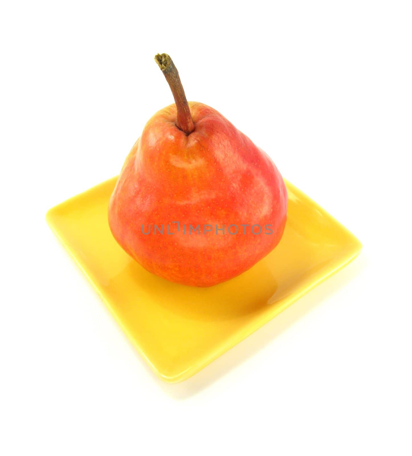 image of a red pear on a yellow plate