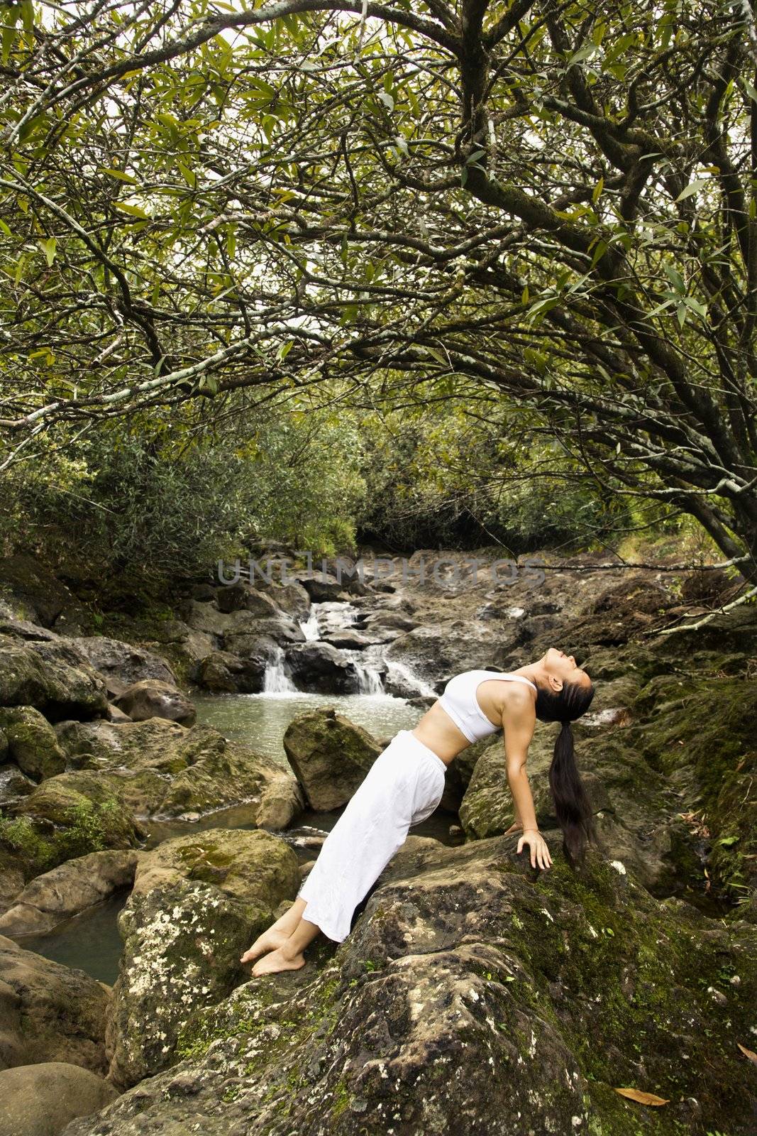 Asian woman doing yoga. by iofoto