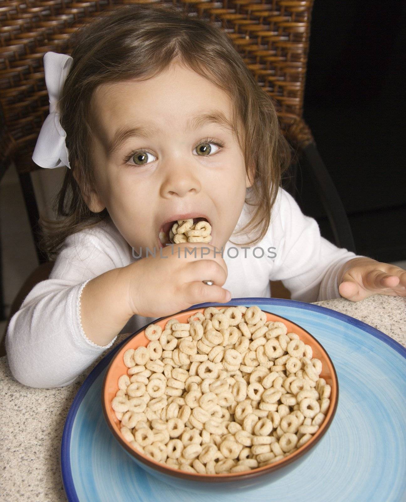 Girl eating cereal. by iofoto