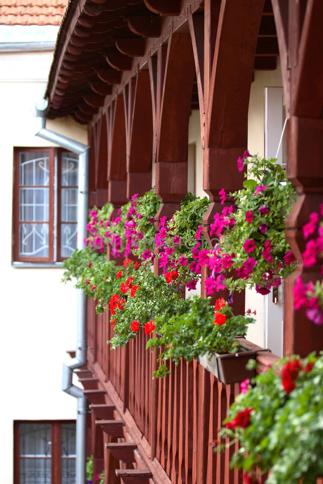 Wrought wooden balcony full of flowers