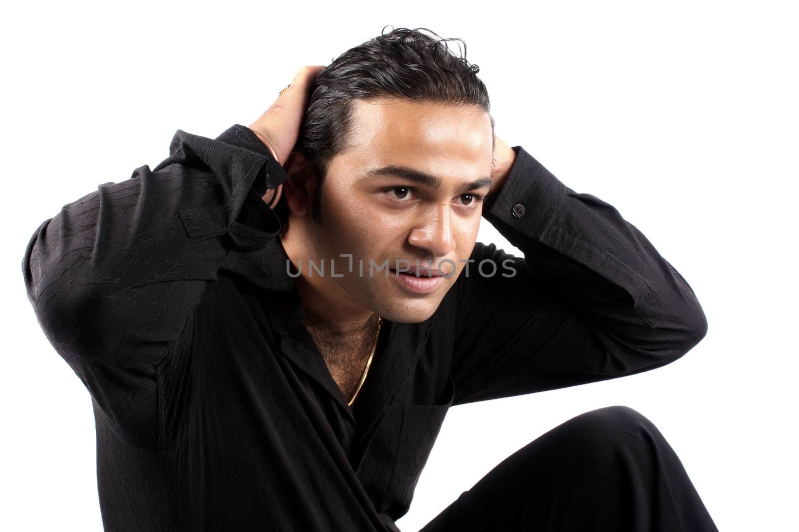 A young tired Indian model setting his hair, isolated on white studio background.