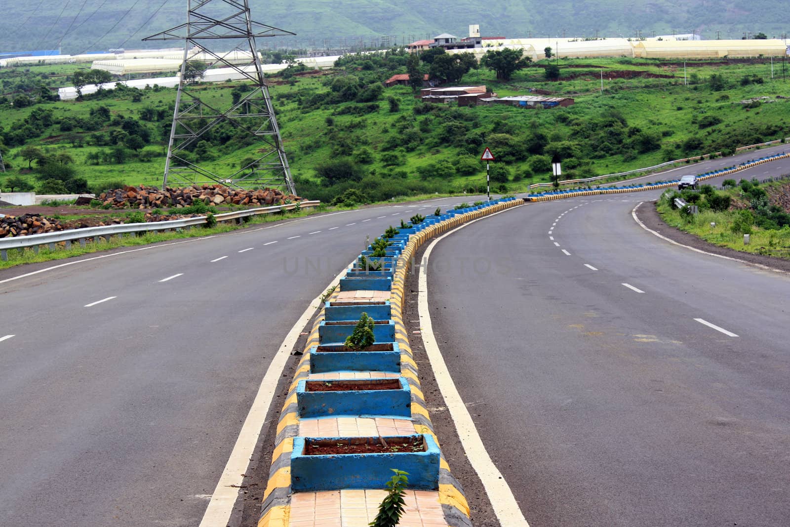 A empty highway turning on a beautiful landscape, in India.