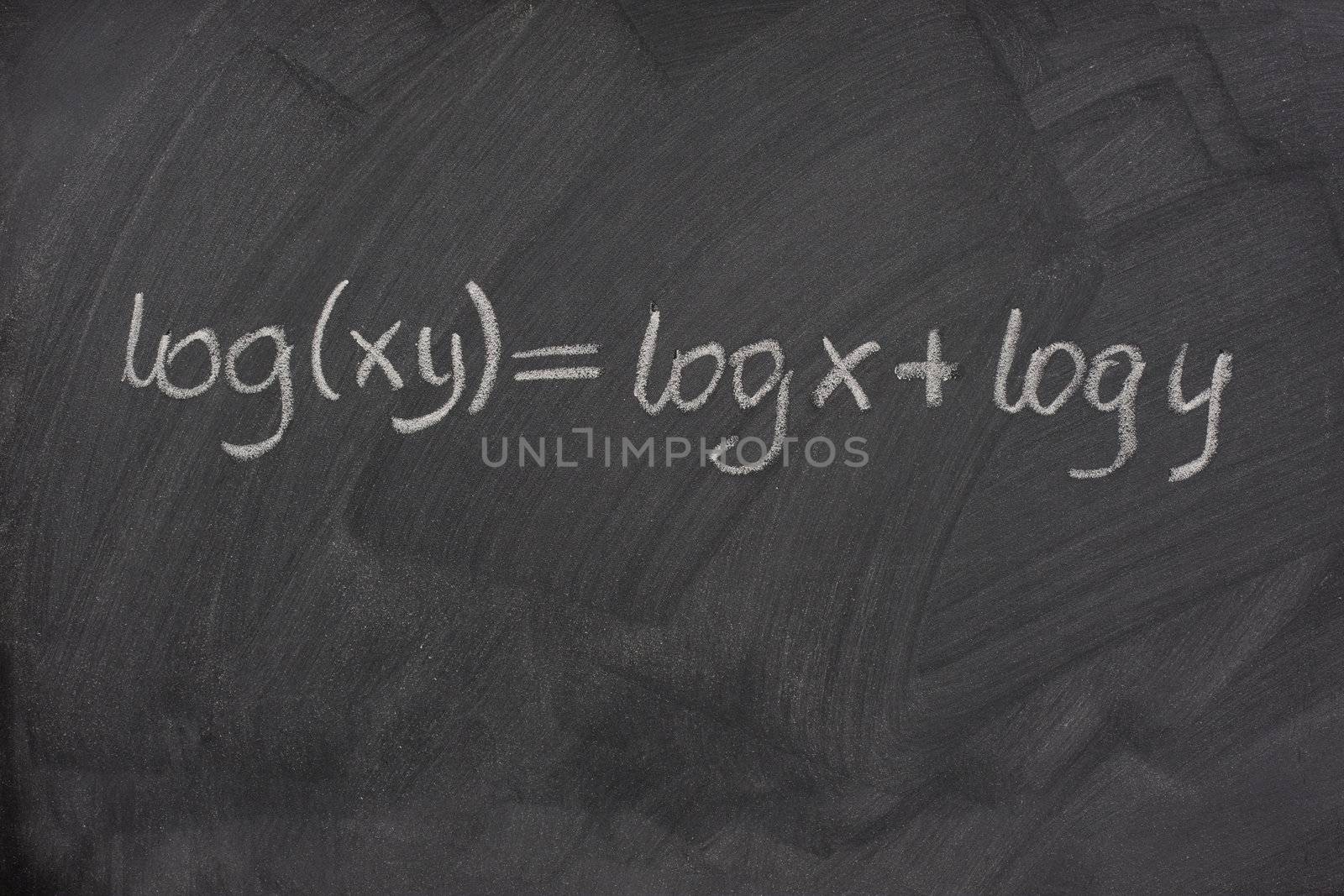 logarithm formula (reduction of multiplication to addition) handwritten with white chalk on a school blackboard with eraser smudges and pattern