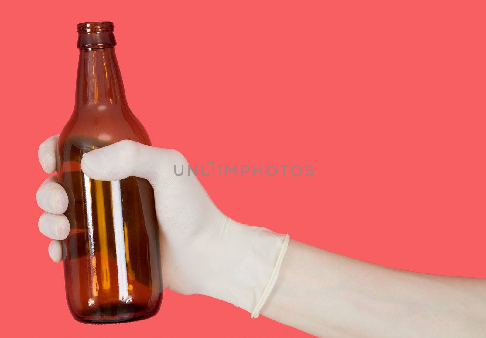 Brown bottle in hand on the red background
