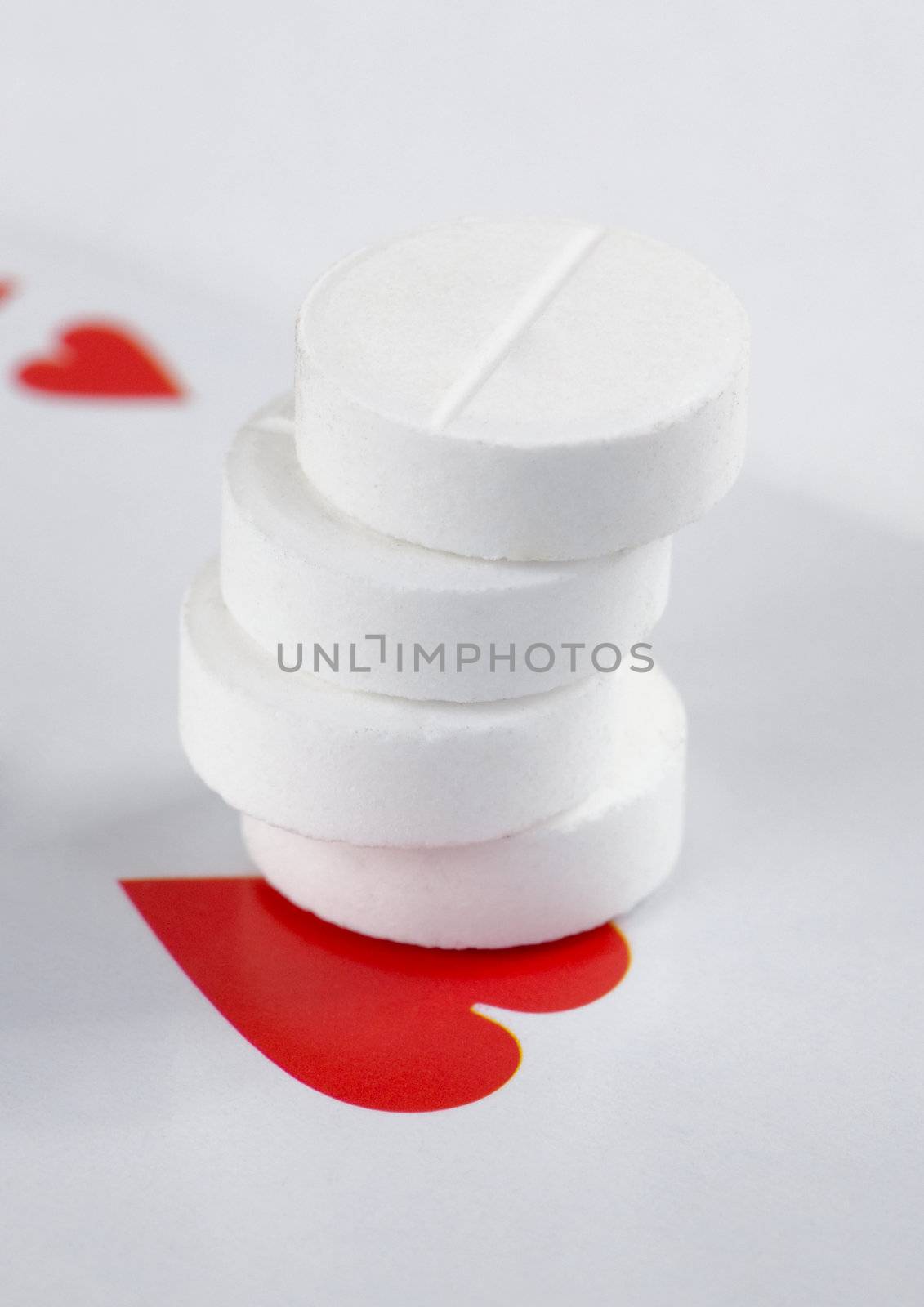 Roll of tablets and heart on the playing card background